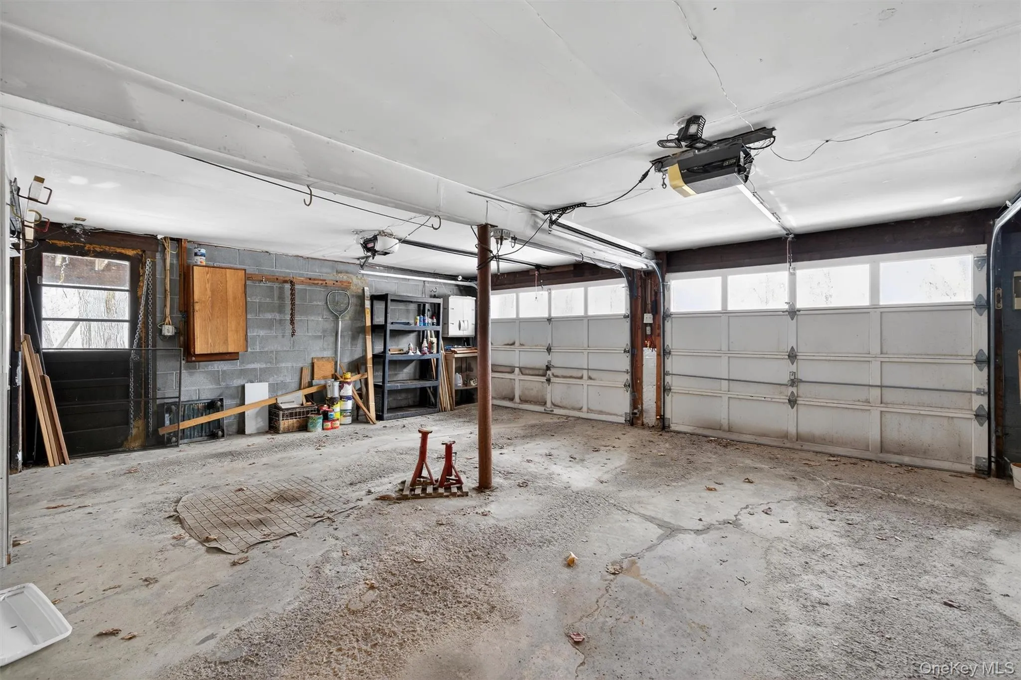 Garage featuring concrete block wall and a garage door opener Garage featuring concrete block wall and a garage door opener