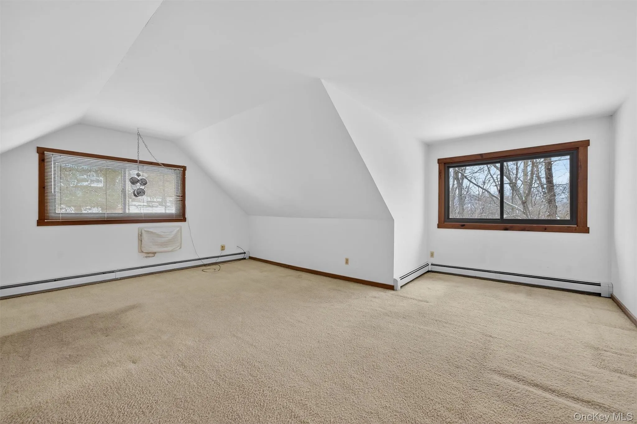 Bonus room featuring lofted ceiling, carpet flooring, a baseboard radiator, and a wall mounted AC Bonus room featuring lofted ceiling, carpet flooring, a baseboard radiator, and a wall mounted AC