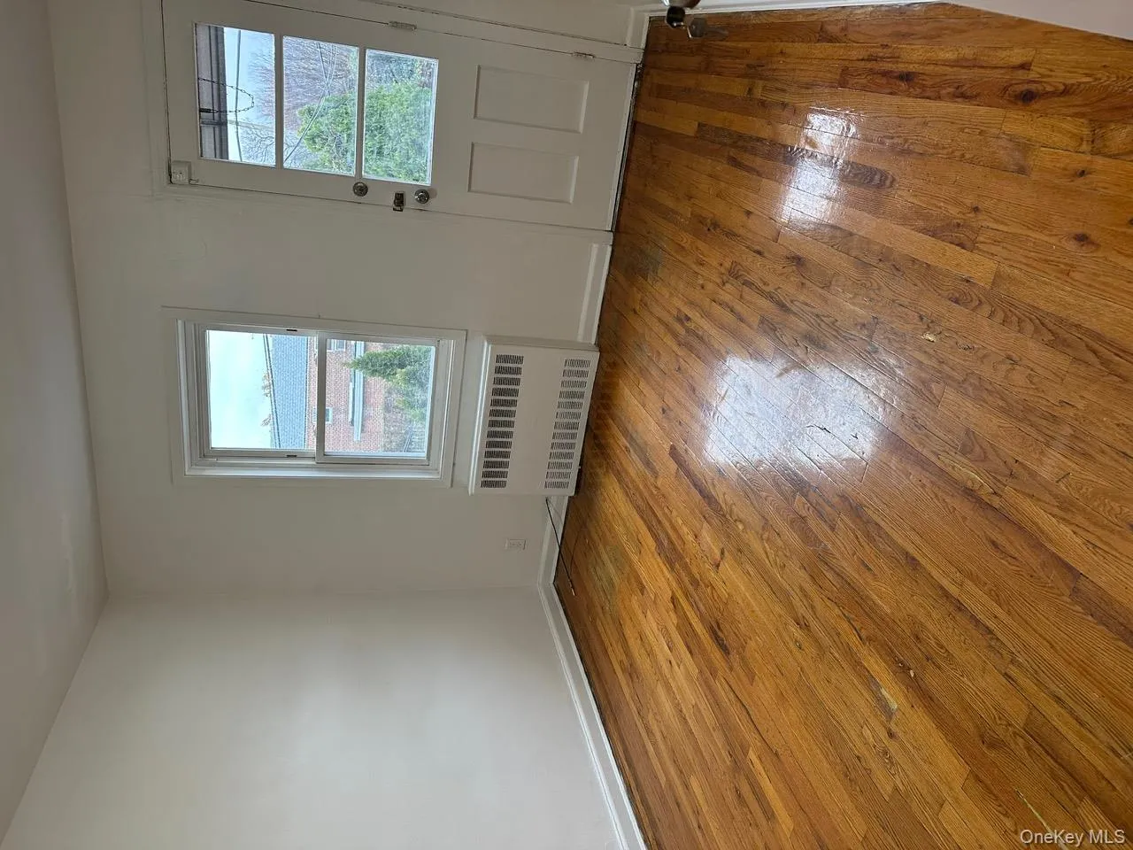 Spare room with radiator heating unit and light wood-style floors Spare room with radiator heating unit and light wood-style floors