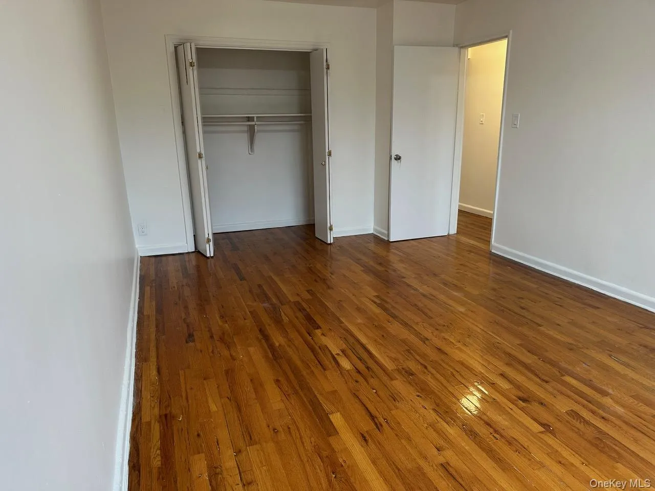 Unfurnished bedroom with dark wood-type flooring and a closet Unfurnished bedroom with dark wood-type flooring and a closet