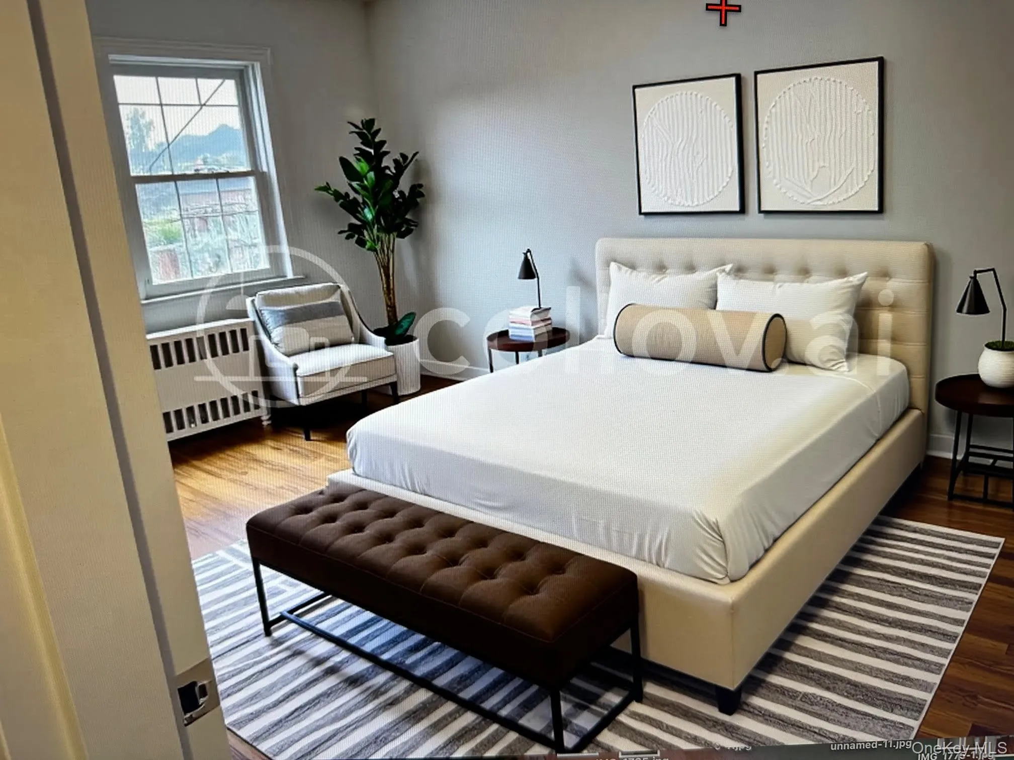 Staged Primary ~ Bedroom featuring radiator heating unit and wood finished floors Staged Primary ~ Bedroom featuring radiator heating unit and wood finished floors