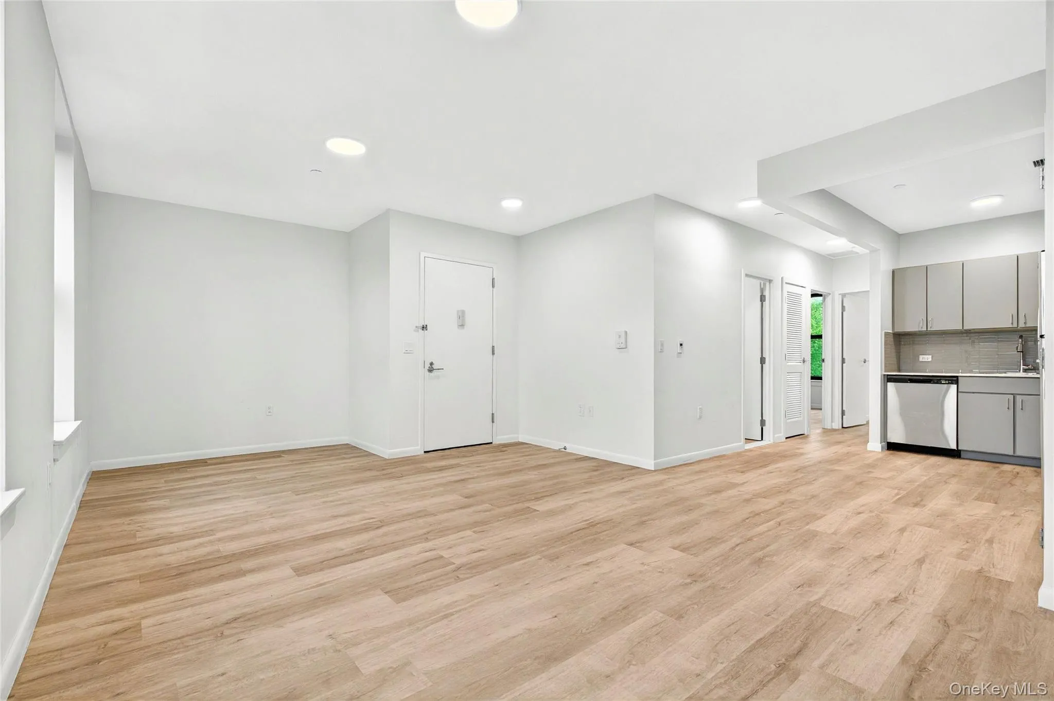 Unfurnished living room with light wood finished floors, baseboards, a sink, and recessed lighting Unfurnished living room with light wood finished floors, baseboards, a sink, and recessed lighting