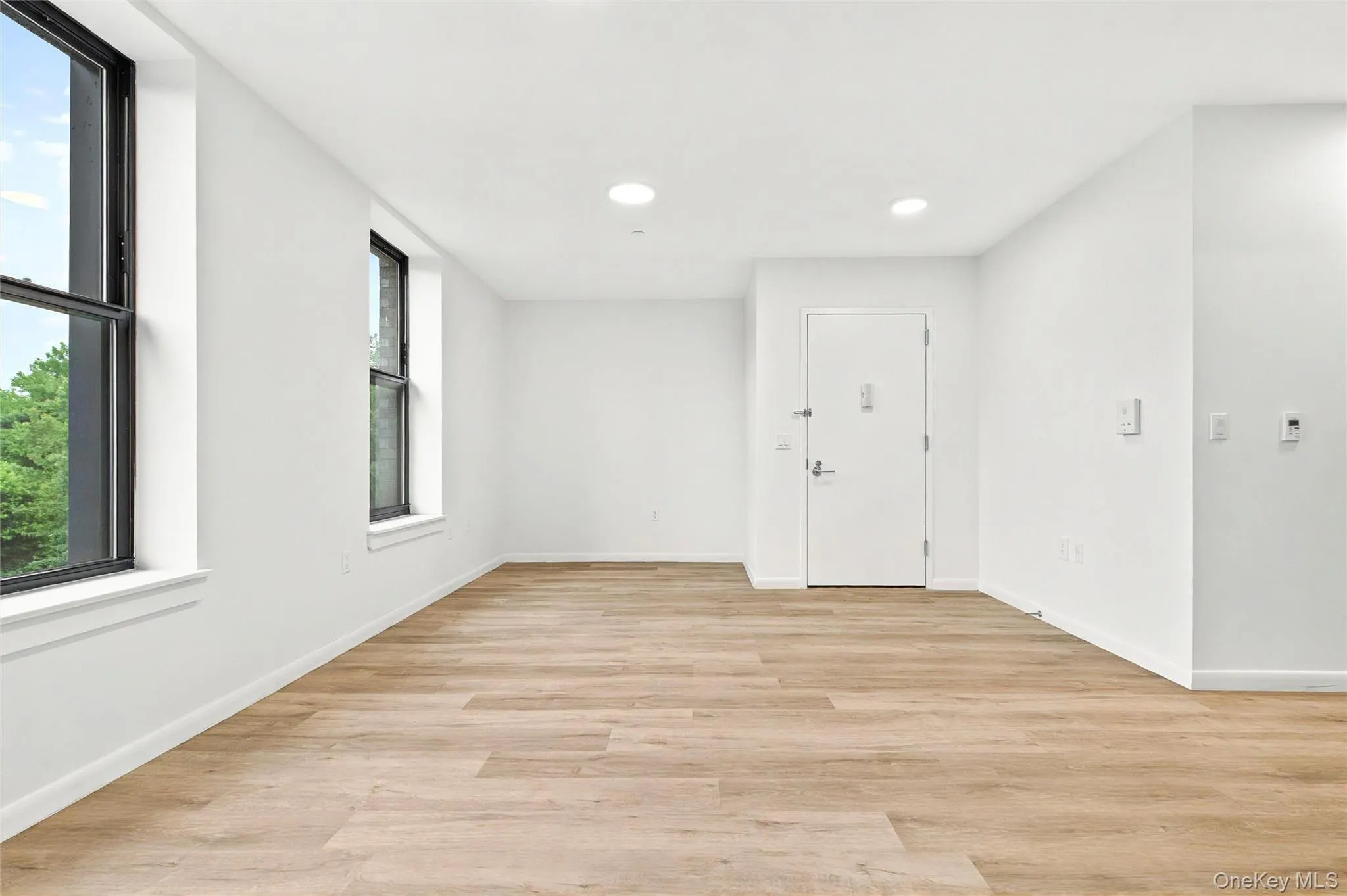 Empty room with recessed lighting, baseboards, and light wood-style floors Empty room with recessed lighting, baseboards, and light wood-style floors