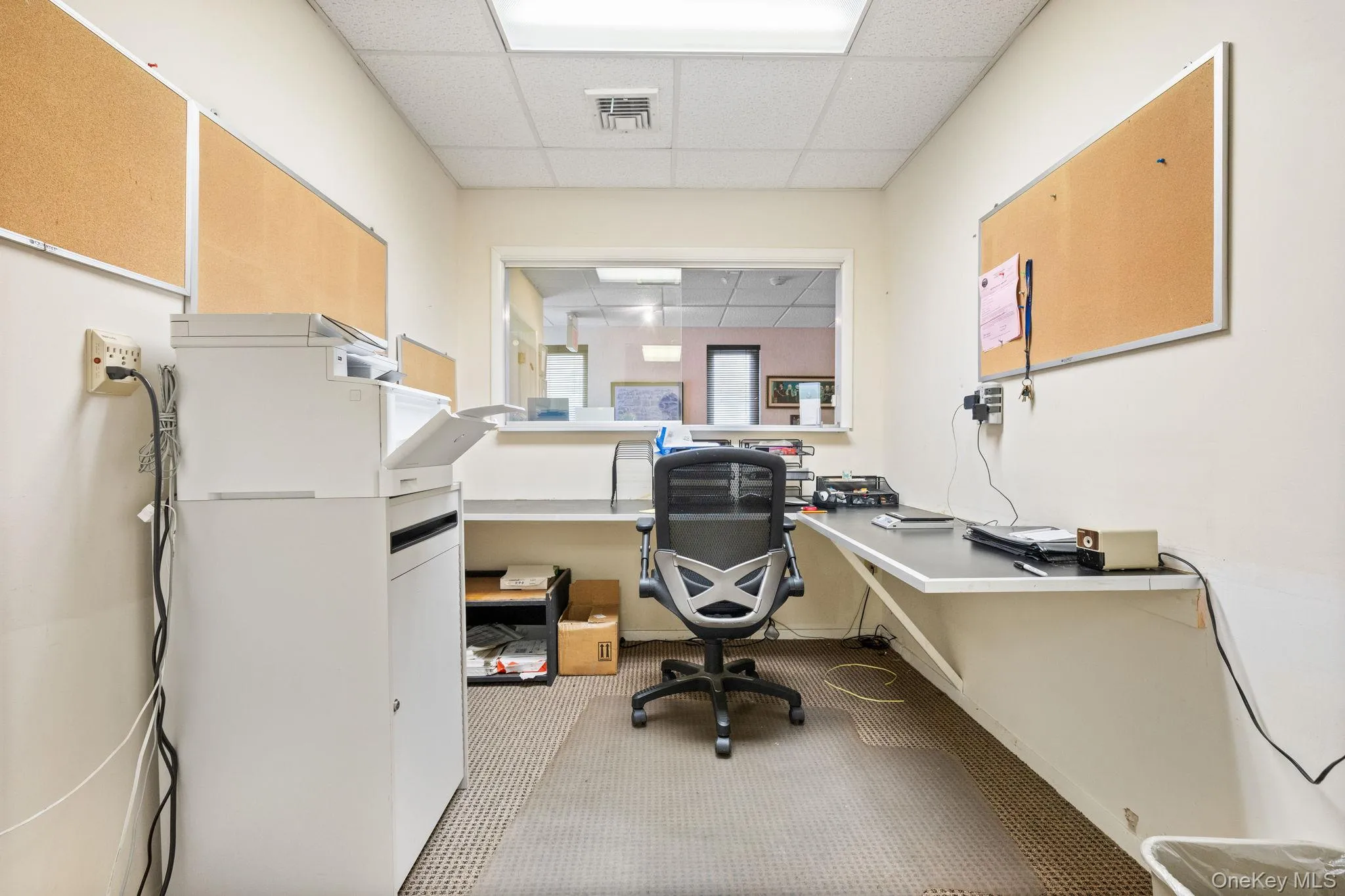 Home office featuring a paneled ceiling and light carpet Home office featuring a paneled ceiling and light carpet
