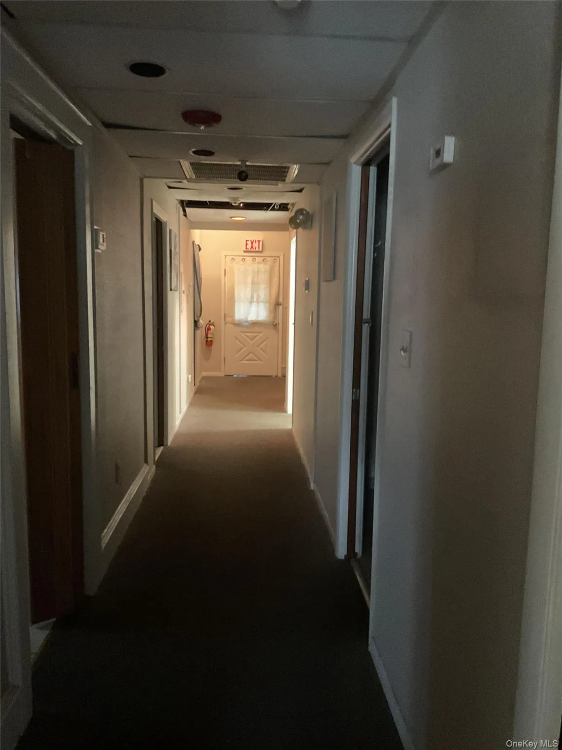 Corridor with baseboards and dark carpet Corridor with baseboards and dark carpet