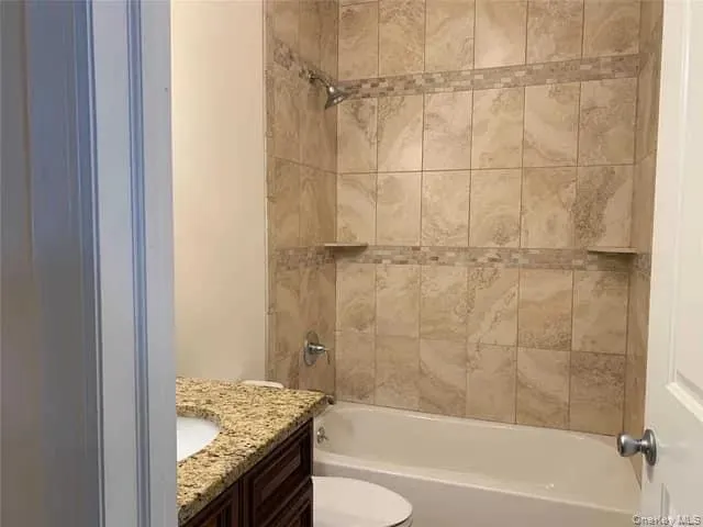 Bathroom featuring vanity and shower / tub combination Bathroom featuring vanity and shower / tub combination