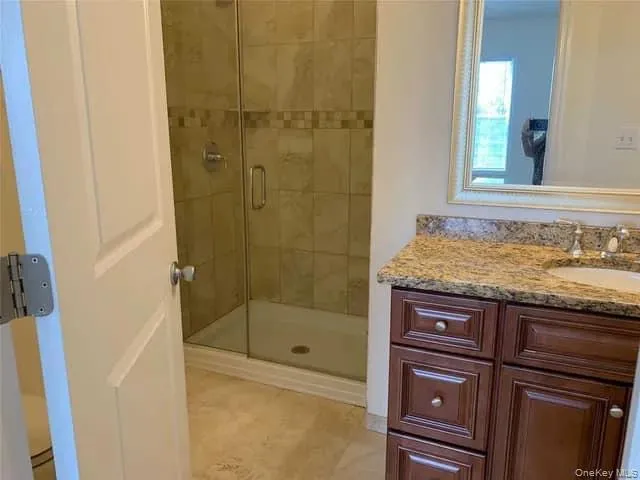 Full bathroom featuring vanity and a stall shower Full bathroom featuring vanity and a stall shower