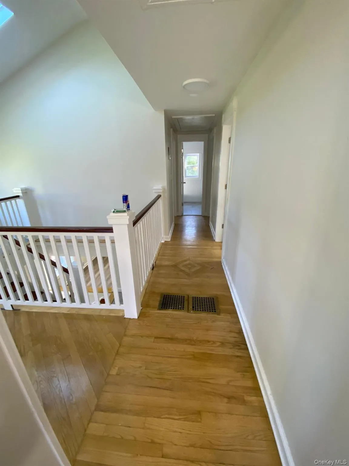 Hall featuring light wood finished floors and an upstairs landing Hall featuring light wood finished floors and an upstairs landing