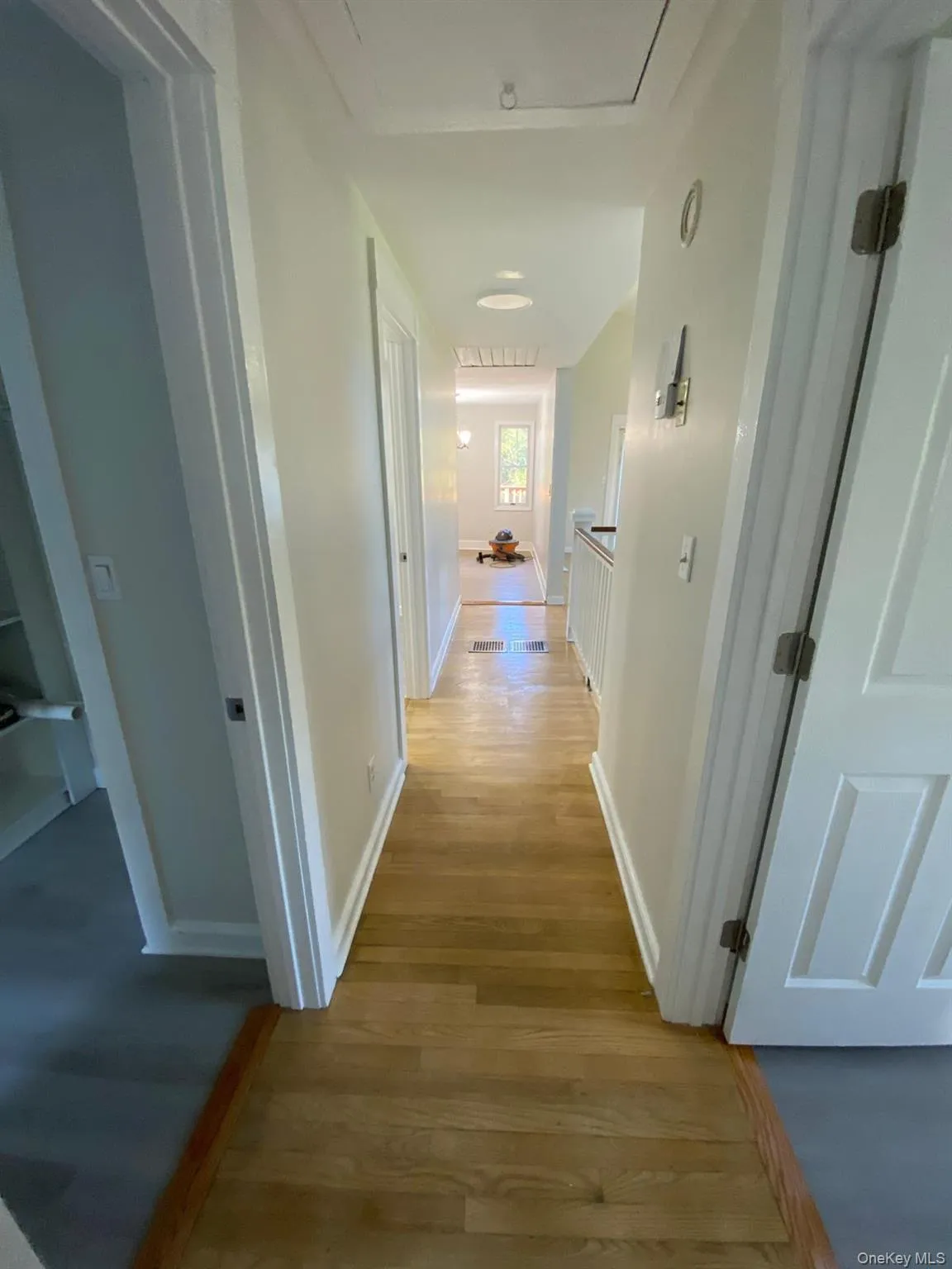 Corridor featuring light wood-type flooring and baseboards Corridor featuring light wood-type flooring and baseboards