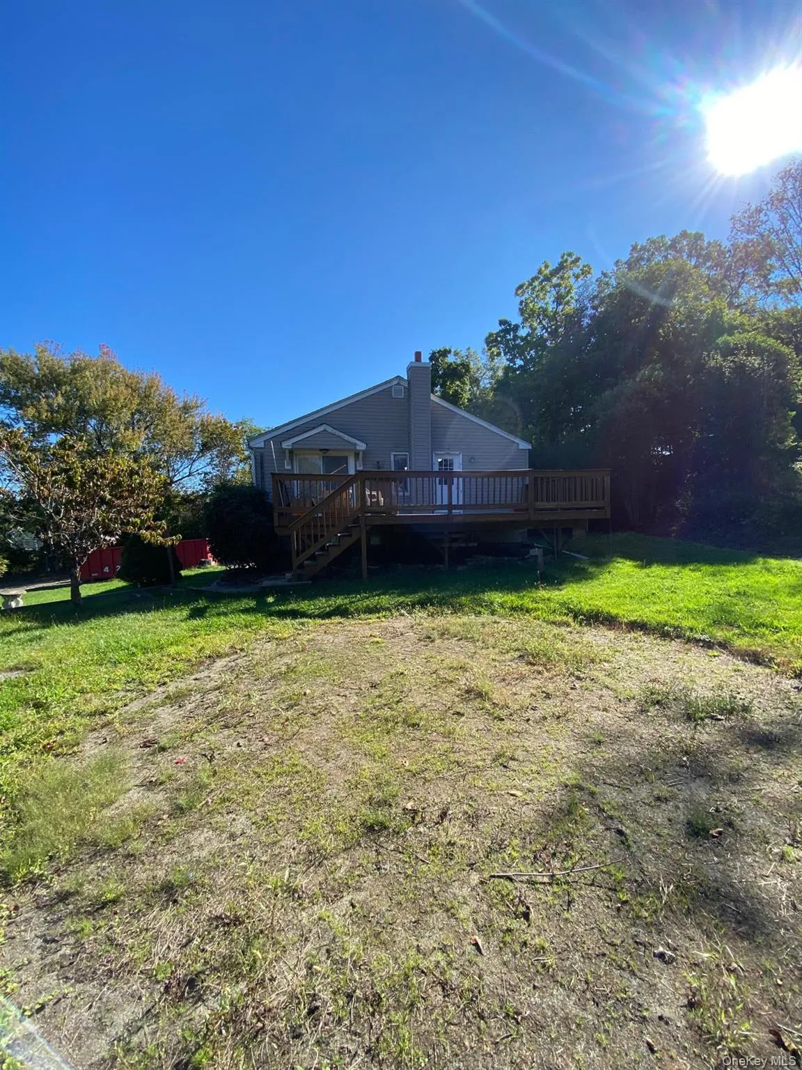 View of green lawn featuring a deck and stairway View of green lawn featuring a deck and stairway