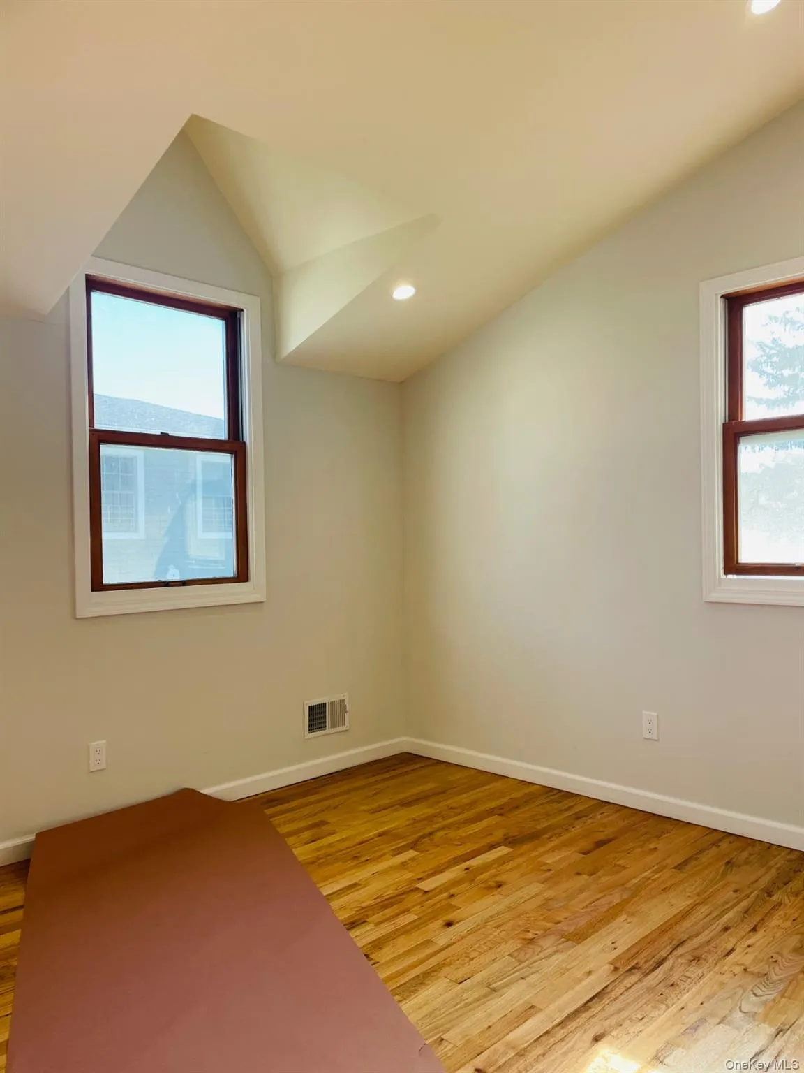 Unfurnished room featuring light wood-style floors, recessed lighting, vaulted ceiling, and healthy amount of natural light Unfurnished room featuring light wood-style floors, recessed lighting, vaulted ceiling, and healthy amount of natural light