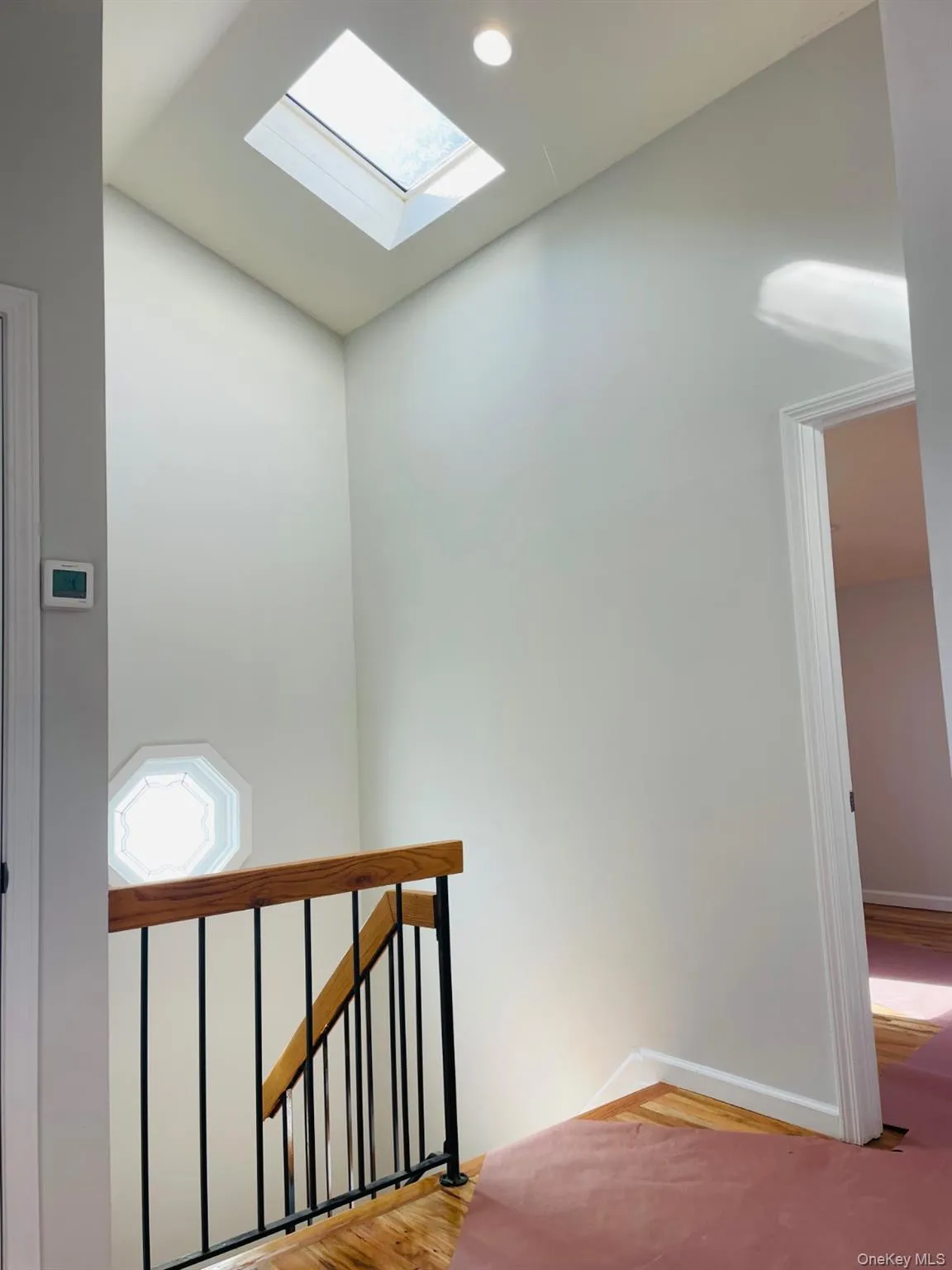 Stairway featuring a skylight and wood finished floors Stairway featuring a skylight and wood finished floors
