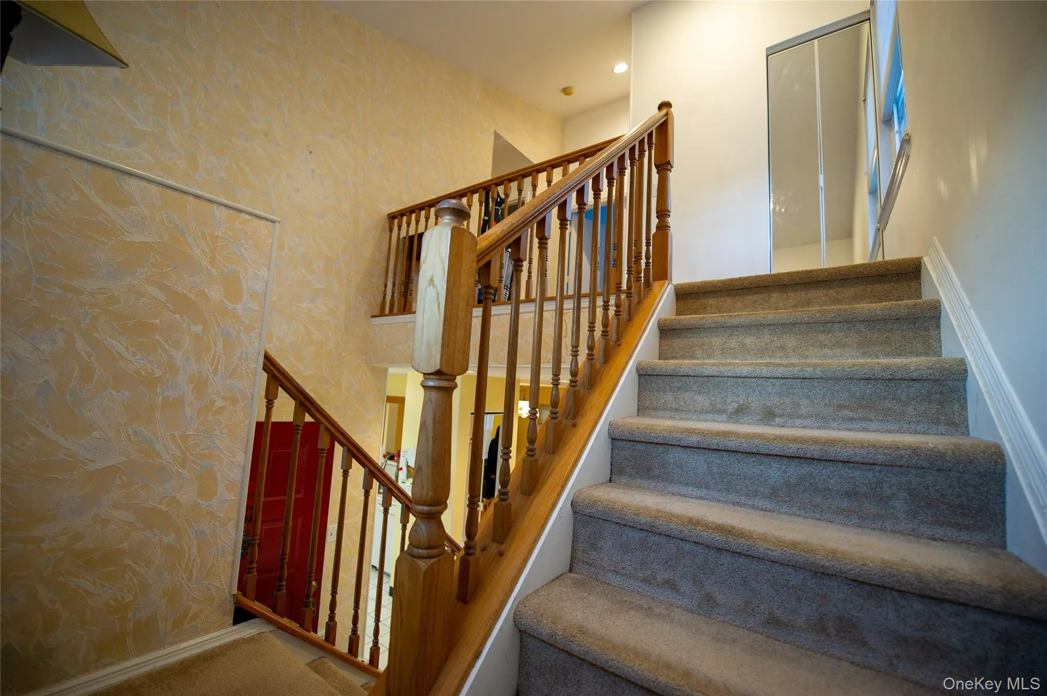 Stairway featuring wallpapered walls, carpet flooring, and recessed lighting Stairway featuring wallpapered walls, carpet flooring, and recessed lighting