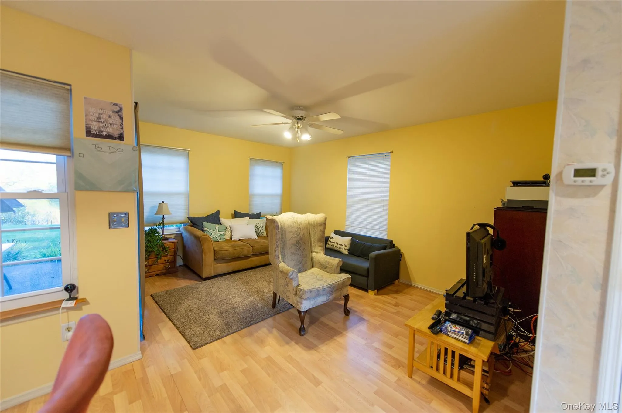 Living area with light wood-style floors and ceiling fan Living area with light wood-style floors and ceiling fan