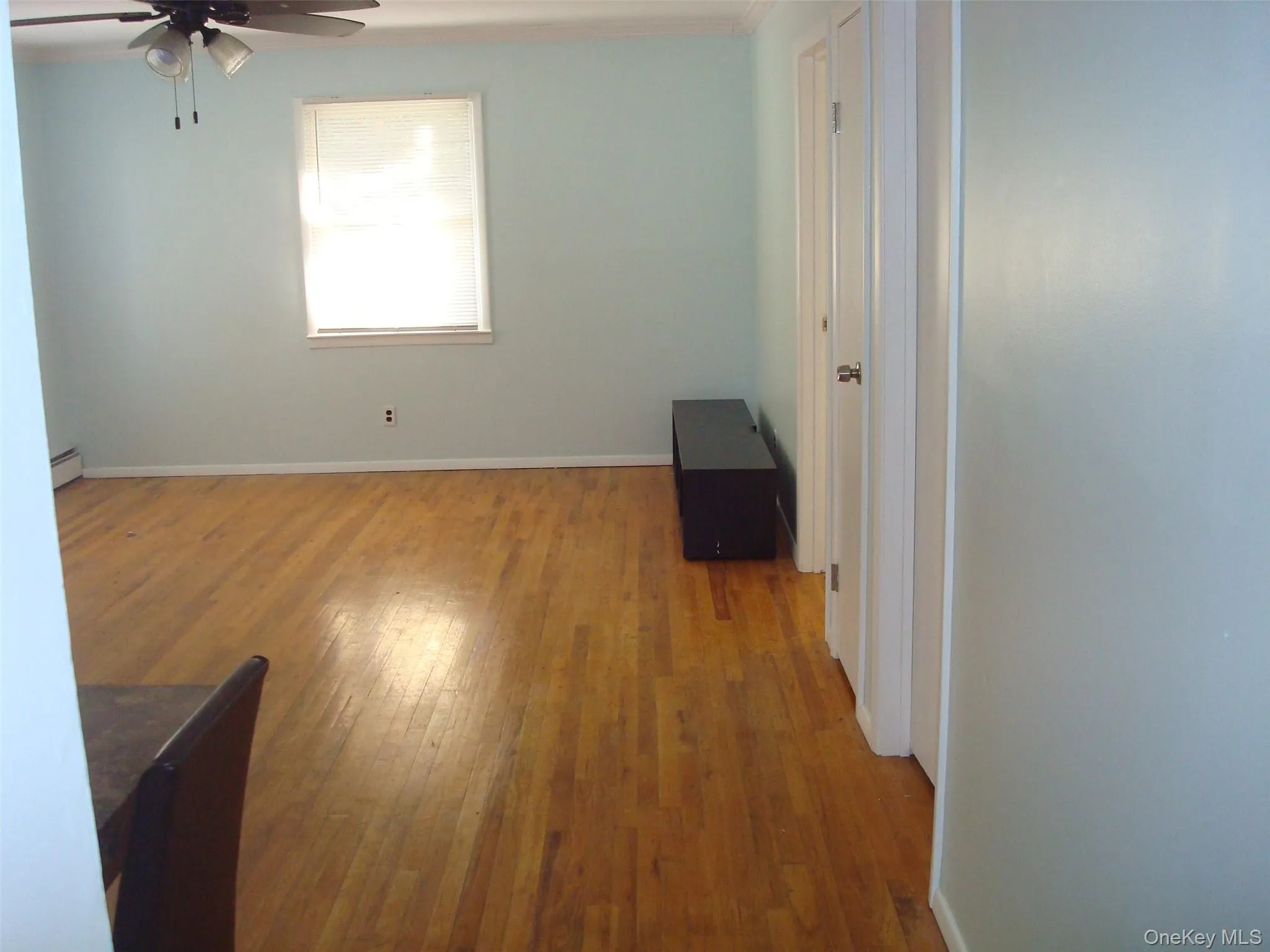 Unfurnished room with light wood finished floors, a ceiling fan, a baseboard heating unit, and ornamental molding Unfurnished room with light wood finished floors, a ceiling fan, a baseboard heating unit, and ornamental molding