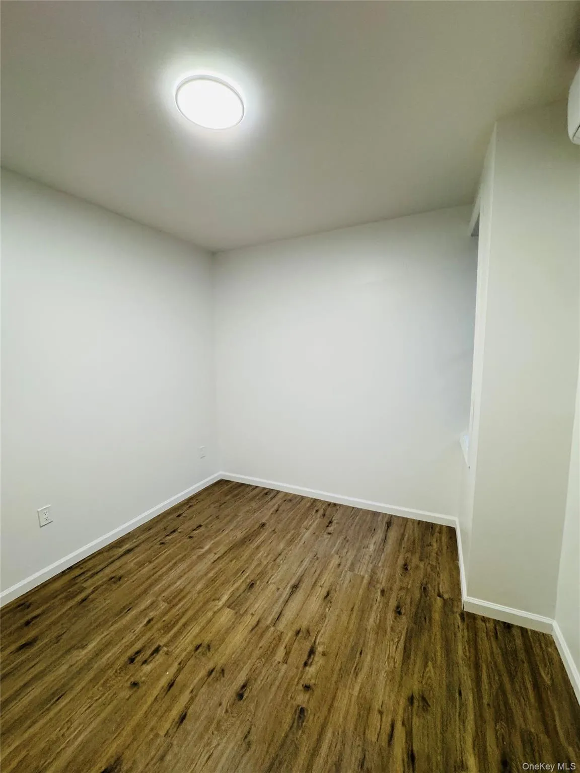 Empty room with dark wood finished floors and baseboards Empty room with dark wood finished floors and baseboards