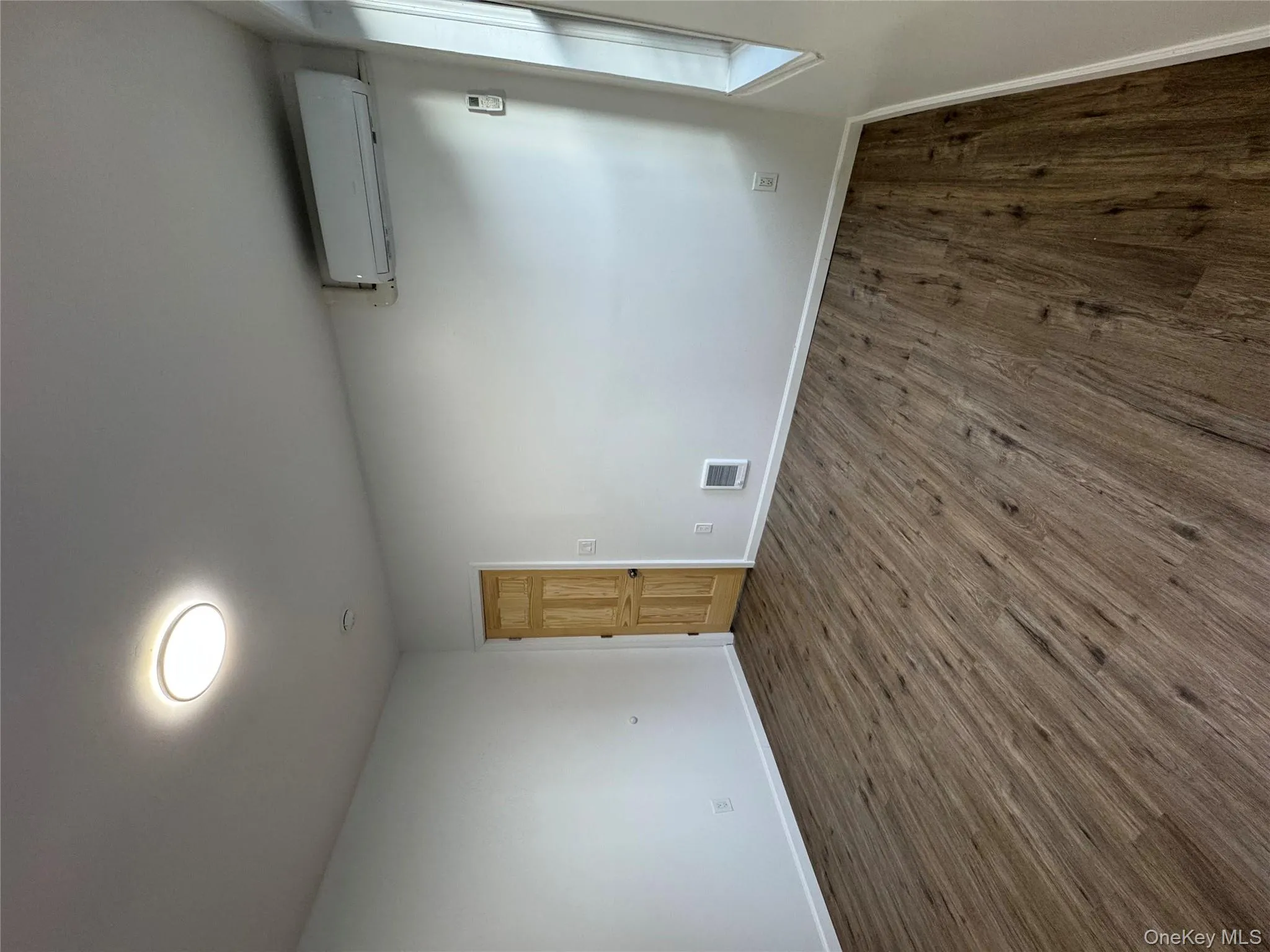 Spare room featuring dark wood finished floors and a wall unit AC Spare room featuring dark wood finished floors and a wall unit AC