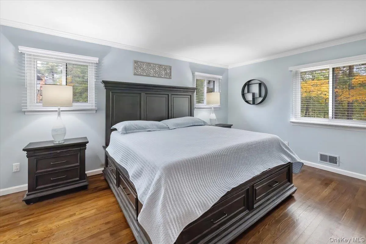 Bedroom featuring dark wood-style flooring and crown molding Bedroom featuring dark wood-style flooring and crown molding
