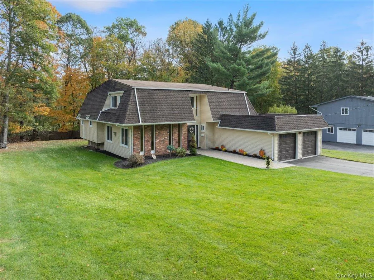 Dutch colonial with a gambrel roof, a front lawn, a shingled roof, and driveway Dutch colonial with a gambrel roof, a front lawn, a shingled roof, and driveway