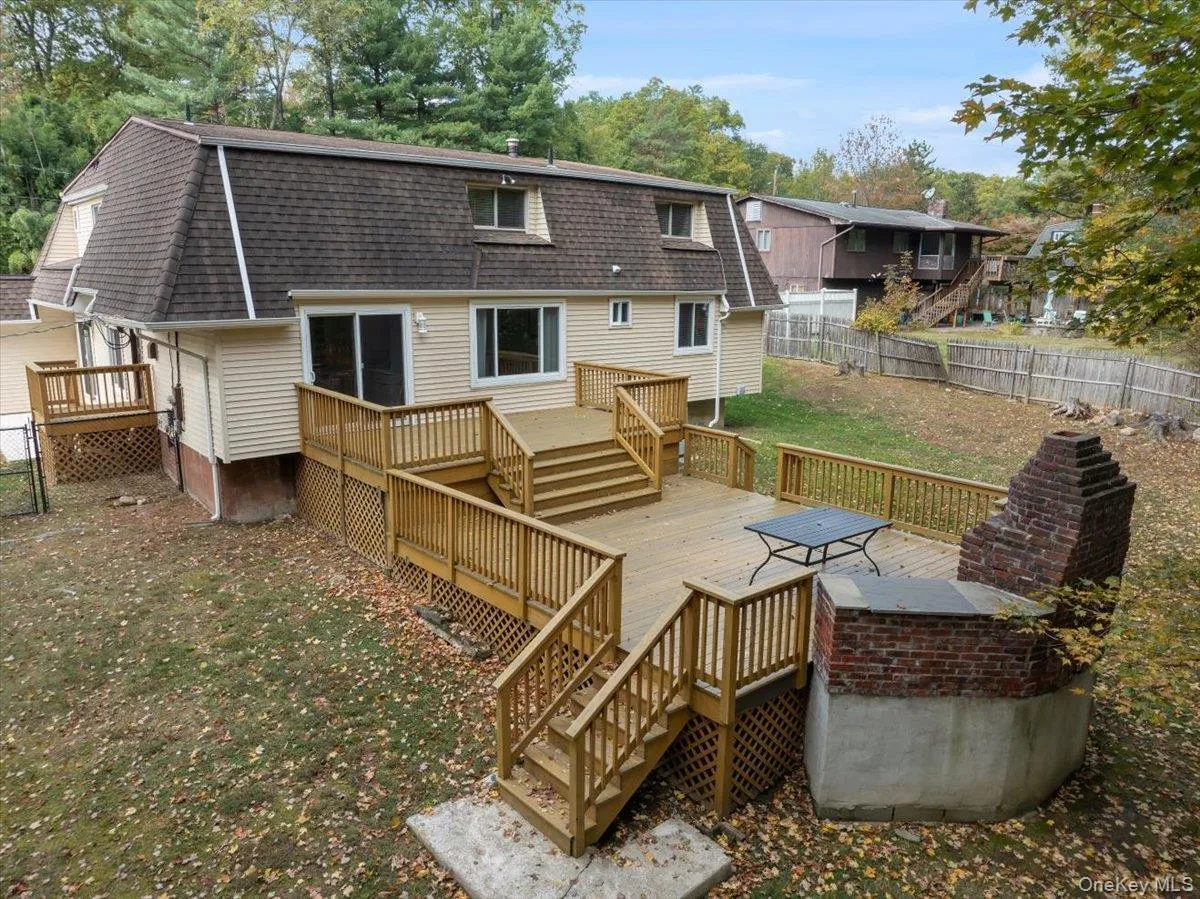 Back of house with a fenced backyard, stairs, a deck, and roof with shingles Back of house with a fenced backyard, stairs, a deck, and roof with shingles