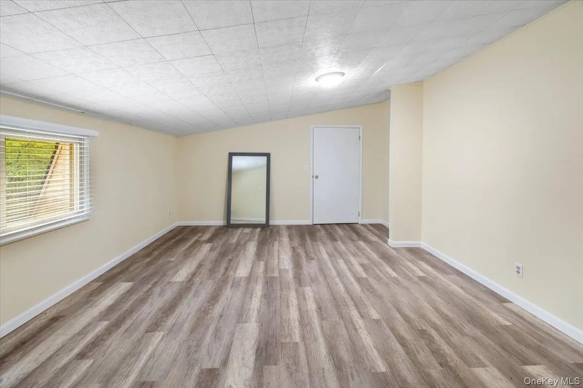 Spare room featuring lofted ceiling and light wood-style flooring Spare room featuring lofted ceiling and light wood-style flooring