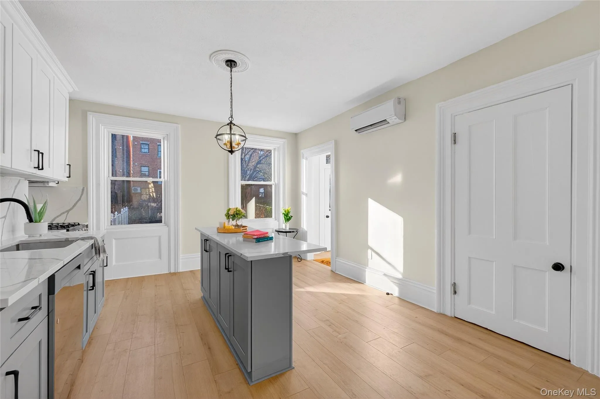 Kitchen with pendant lighting, white cabinetry, light wood-style flooring, and light stone counters Kitchen with pendant lighting, white cabinetry, light wood-style flooring, and light stone counters