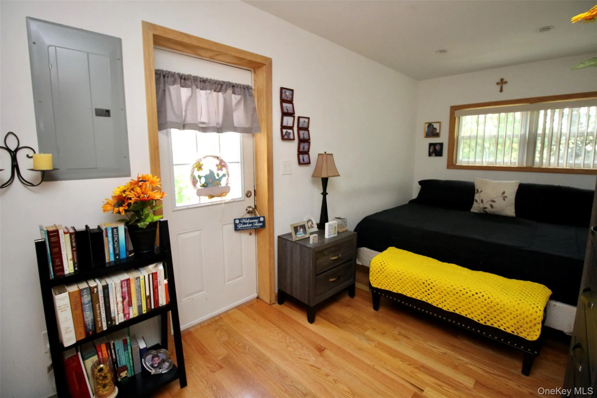 Bedroom with electric panel, multiple windows, and light wood-style flooring Bedroom with electric panel, multiple windows, and light wood-style flooring
