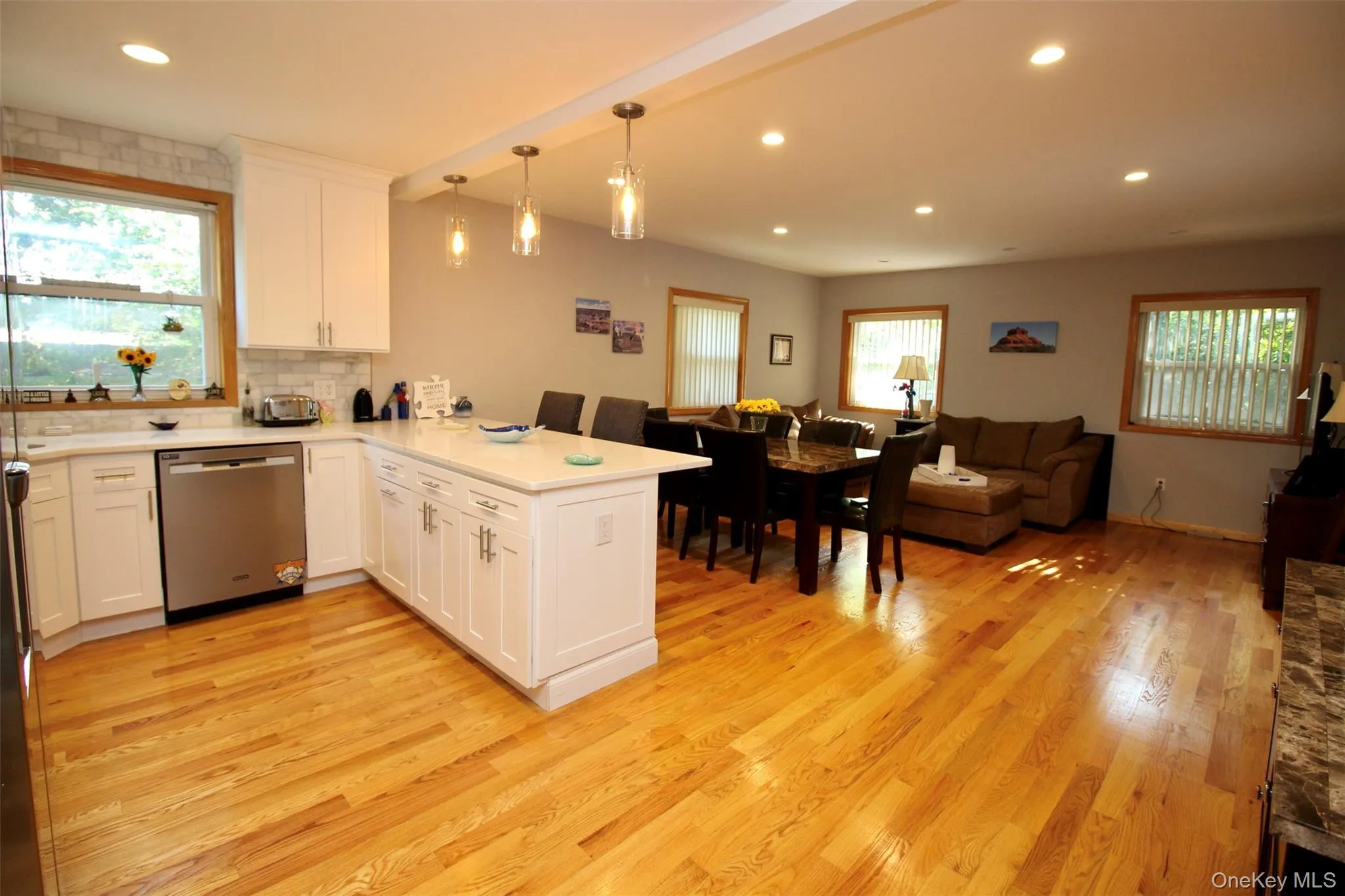 Kitchen featuring open floor plan, a peninsula, pendant lighting, stainless steel dishwasher, and recessed lighting Kitchen featuring open floor plan, a peninsula, pendant lighting, stainless steel dishwasher, and recessed lighting