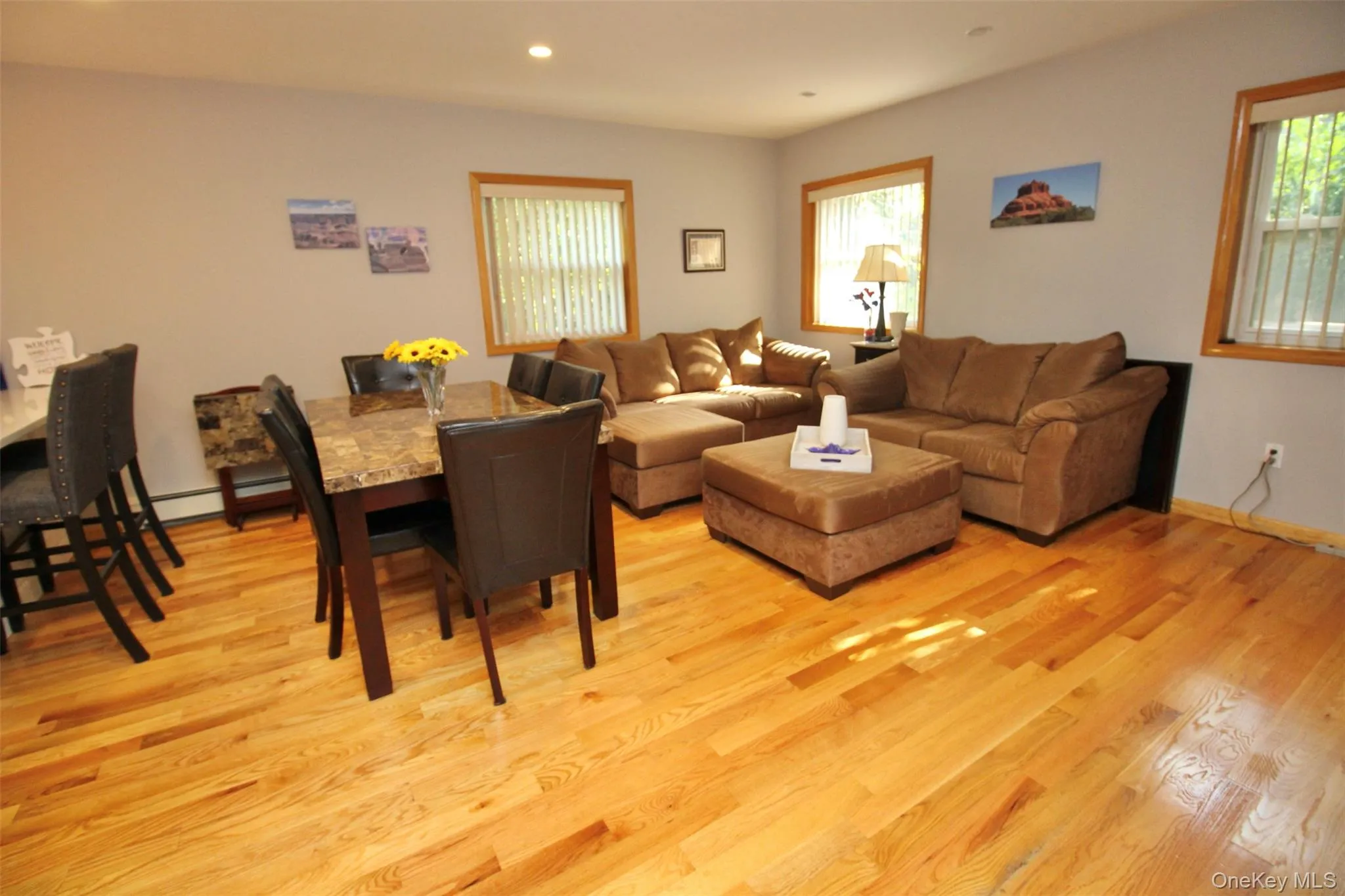 Living room with light wood-style flooring, recessed lighting, and plenty of natural light Living room with light wood-style flooring, recessed lighting, and plenty of natural light