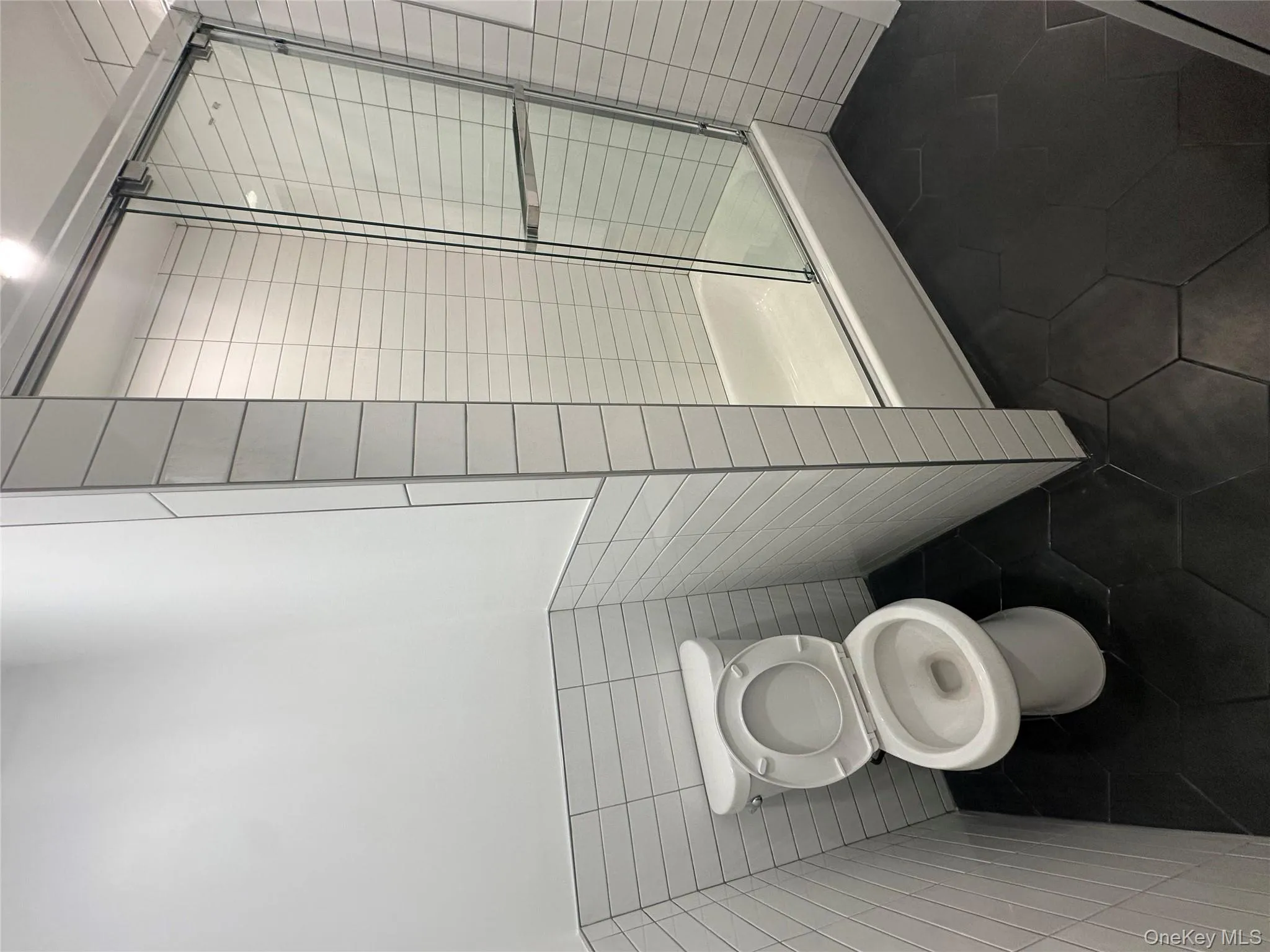 Bathroom featuring tile walls and dark tile patterned flooring Bathroom featuring tile walls and dark tile patterned flooring