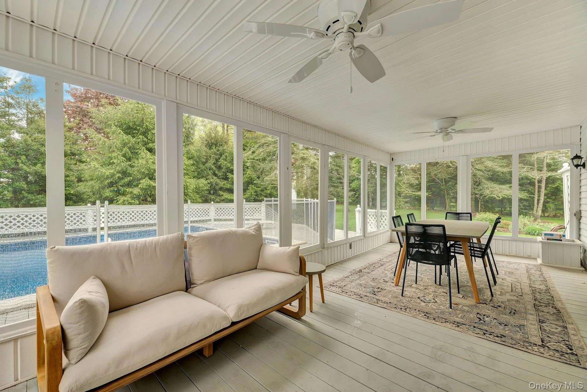 Sunroom / solarium featuring outdoor dining space, an outdoor hangout area, view of scattered trees, and a ceiling fan Sunroom / solarium featuring outdoor dining space, an outdoor hangout area, view of scattered trees, and a ceiling fan