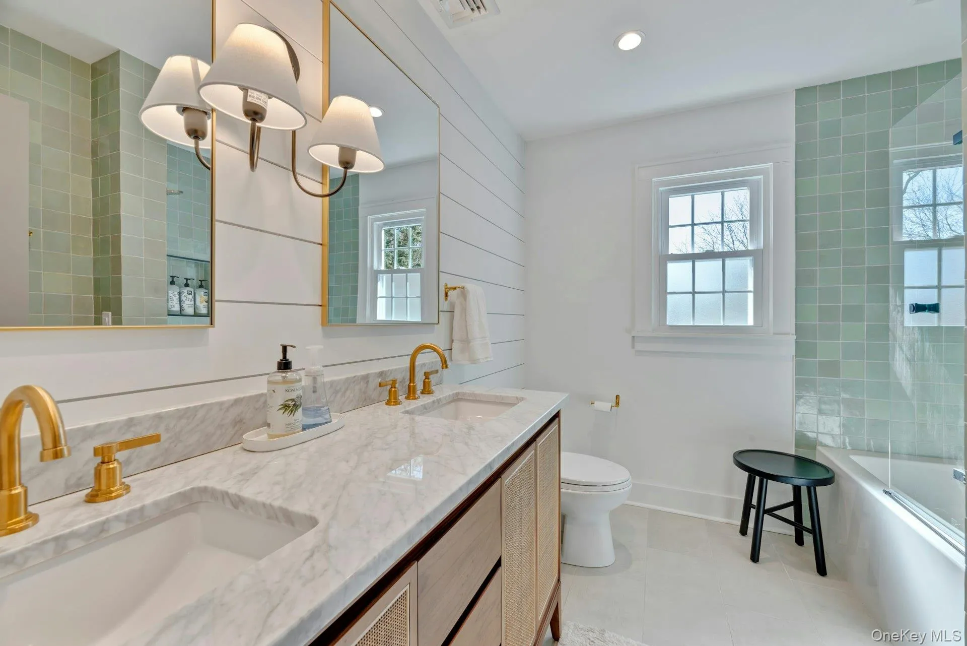 Full bath with healthy amount of natural light, shower / washtub combination, double vanity, light tile patterned flooring, and recessed lighting Full bath with healthy amount of natural light, shower / washtub combination, double vanity, light tile patterned flooring, and recessed lighting