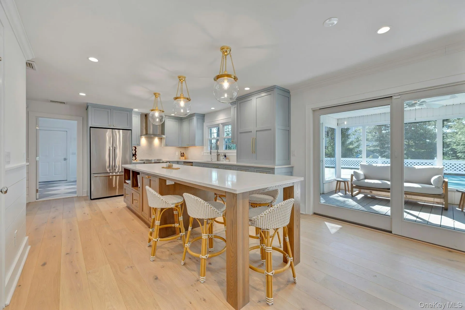 Kitchen featuring hanging light fixtures, high quality fridge, gray cabinets, light wood finished floors, and recessed lighting Kitchen featuring hanging light fixtures, high quality fridge, gray cabinets, light wood finished floors, and recessed lighting