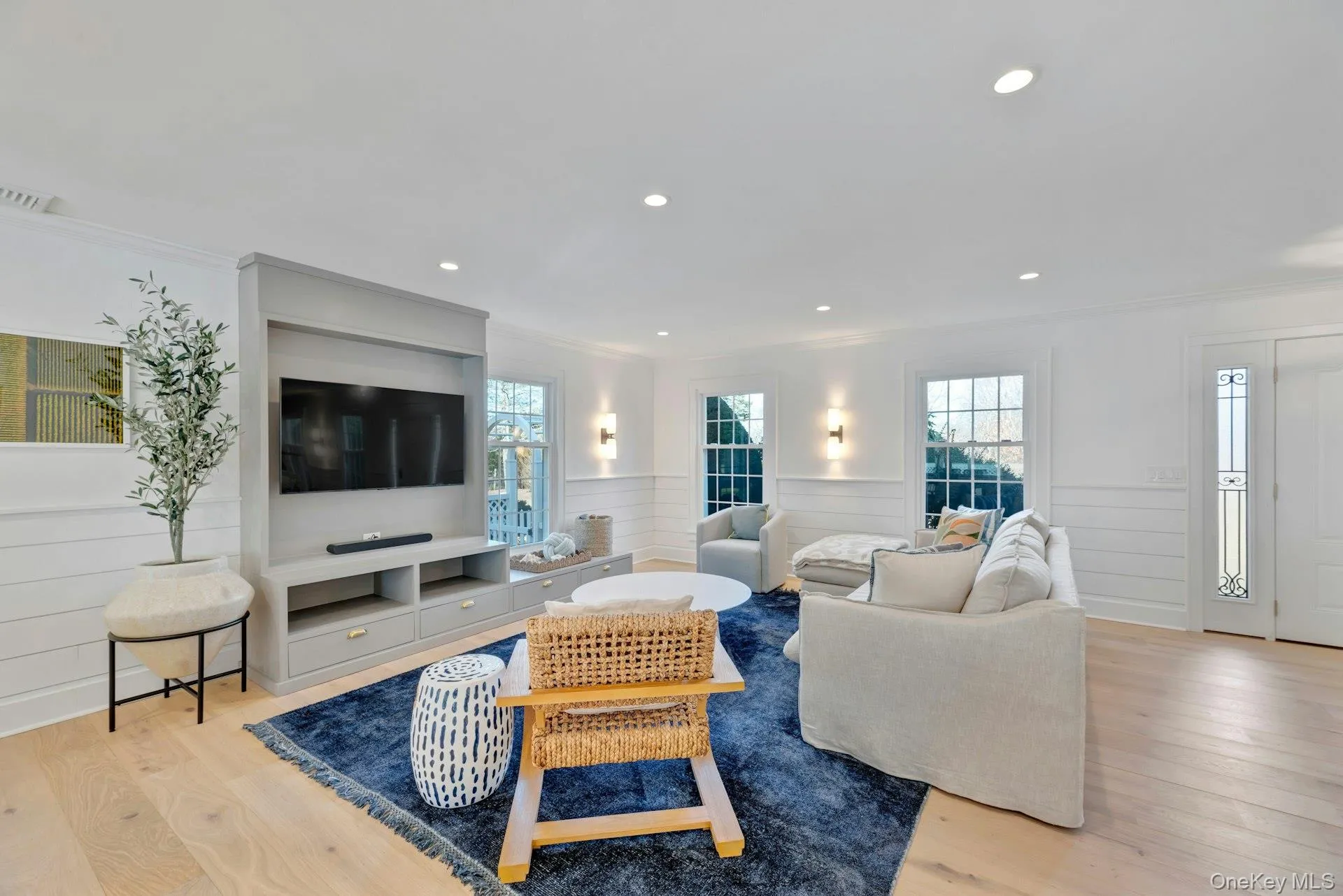 Living area featuring light wood-style flooring, crown molding, wainscoting, and recessed lighting Living area featuring light wood-style flooring, crown molding, wainscoting, and recessed lighting