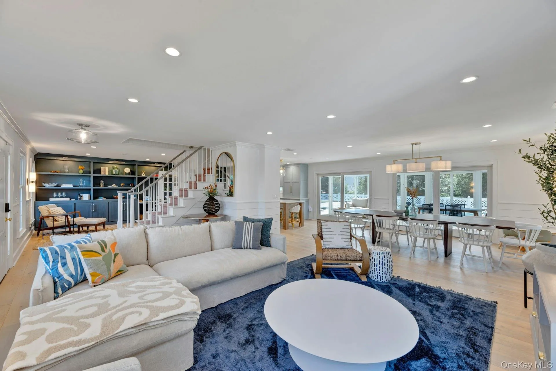 Living area featuring wood finished floors, stairs, a decorative wall, recessed lighting, and built in features Living area featuring wood finished floors, stairs, a decorative wall, recessed lighting, and built in features