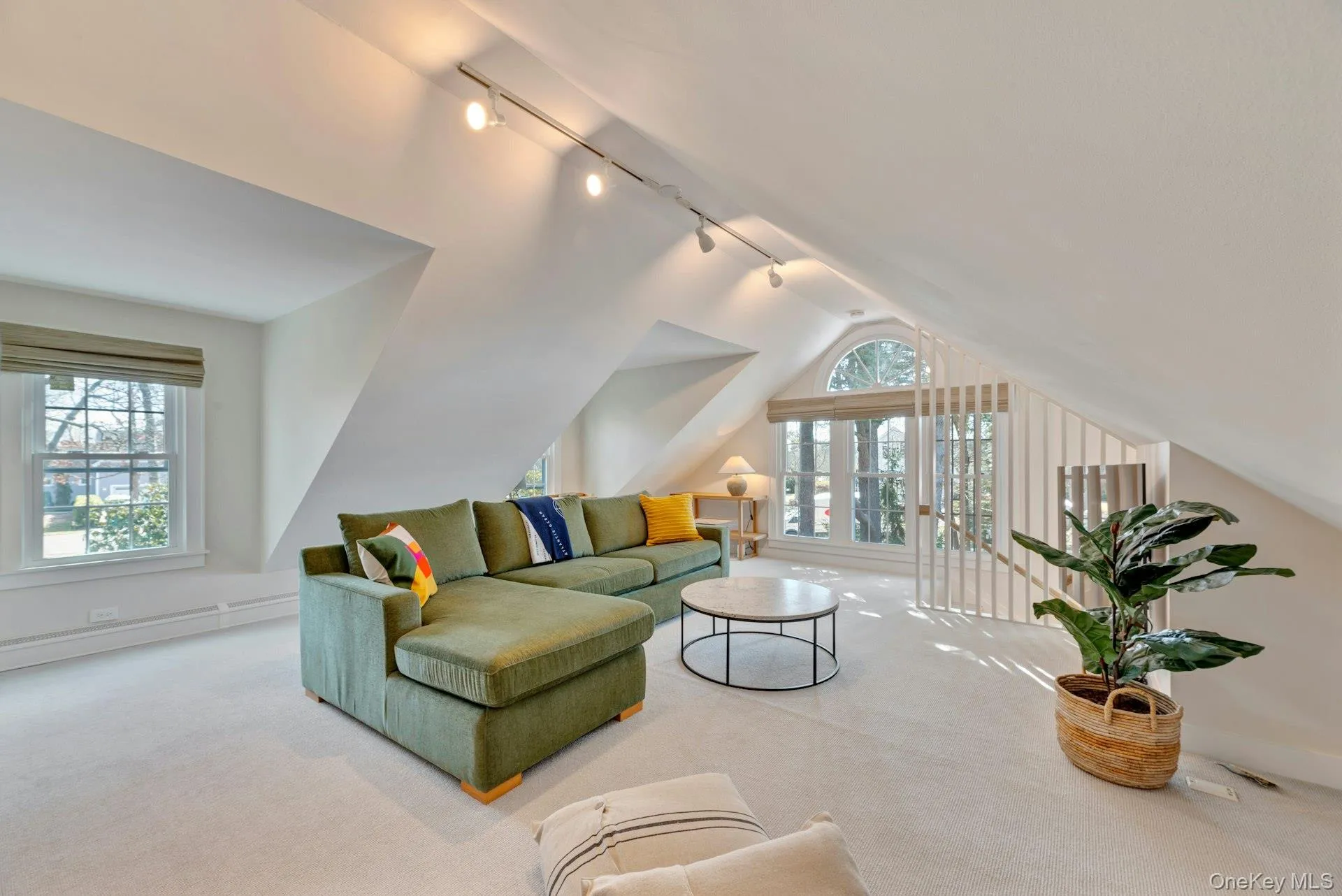 Carpeted living room with lofted ceiling and rail lighting Carpeted living room with lofted ceiling and rail lighting