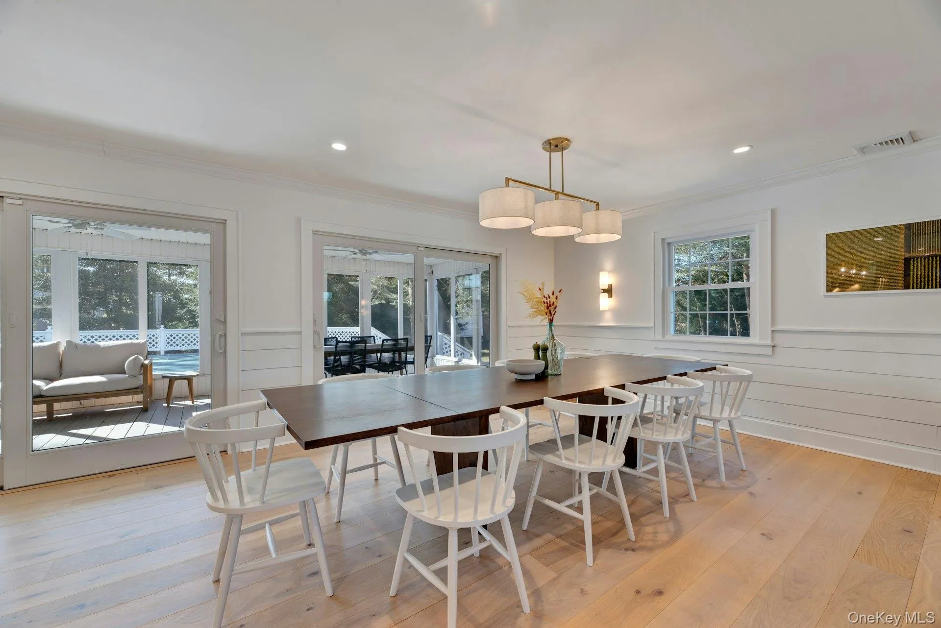 Dining area featuring wainscoting, light wood-style floors, crown molding, and recessed lighting Dining area featuring wainscoting, light wood-style floors, crown molding, and recessed lighting