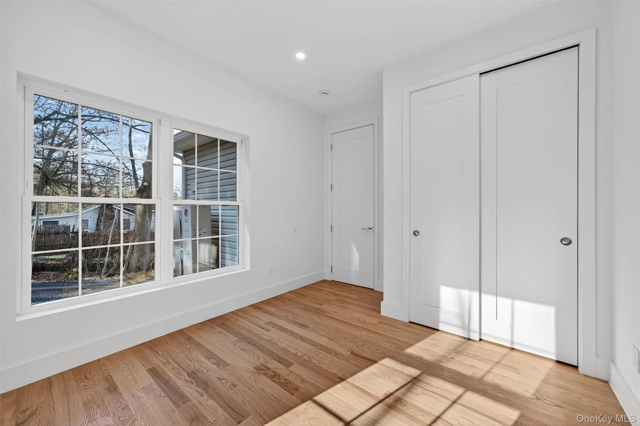 Unfurnished bedroom featuring light wood-style flooring, a closet, and recessed lighting Unfurnished bedroom featuring light wood-style flooring, a closet, and recessed lighting