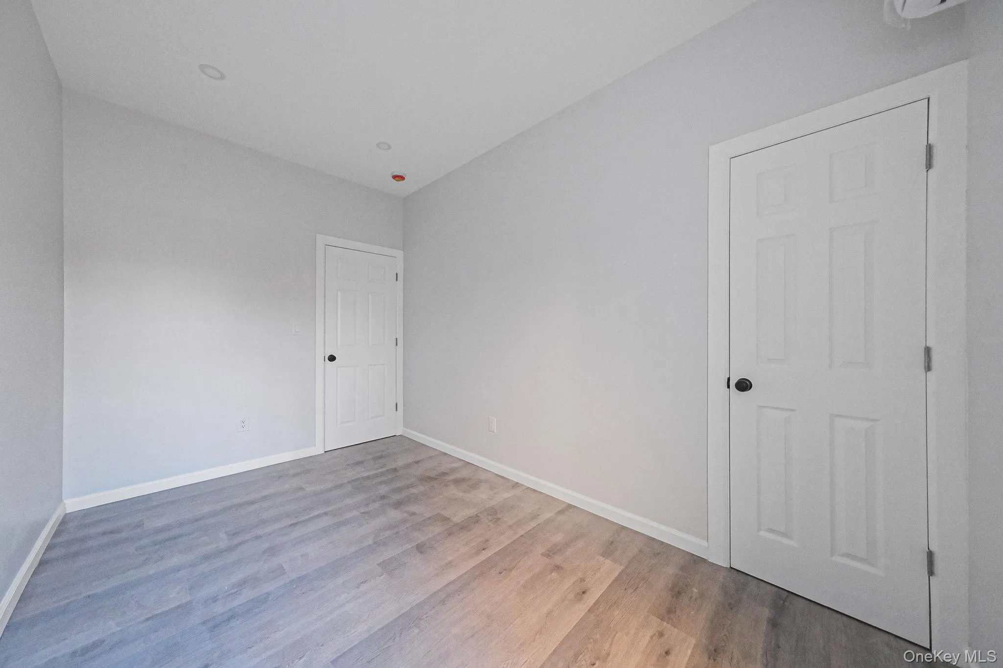 Spare room with baseboards and light wood-style flooring Spare room with baseboards and light wood-style flooring