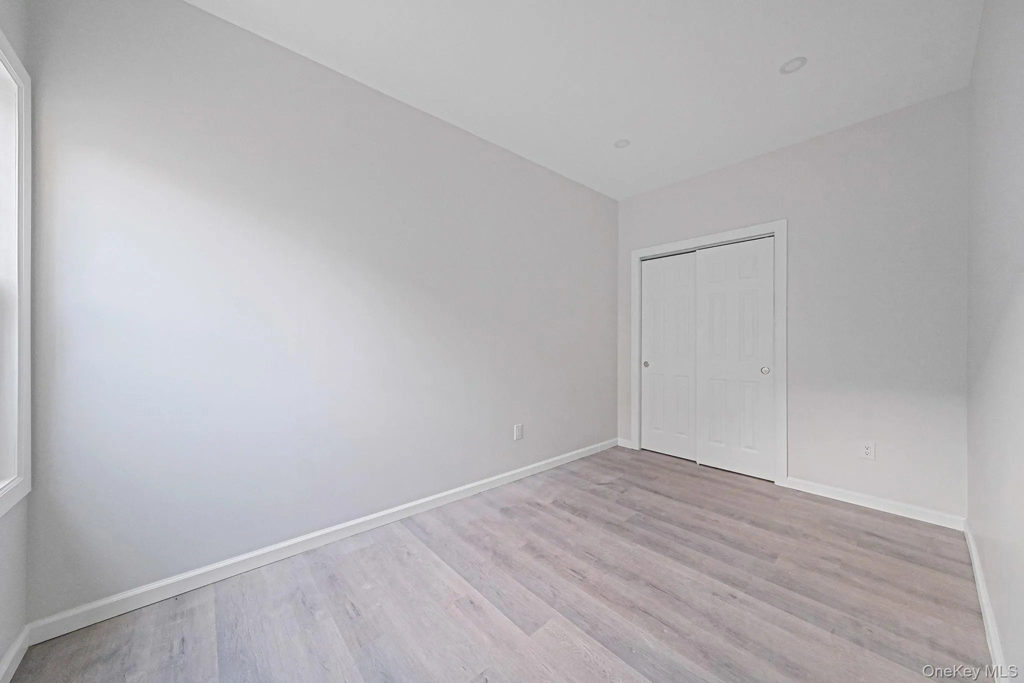Unfurnished bedroom with light wood finished floors and a closet Unfurnished bedroom with light wood finished floors and a closet