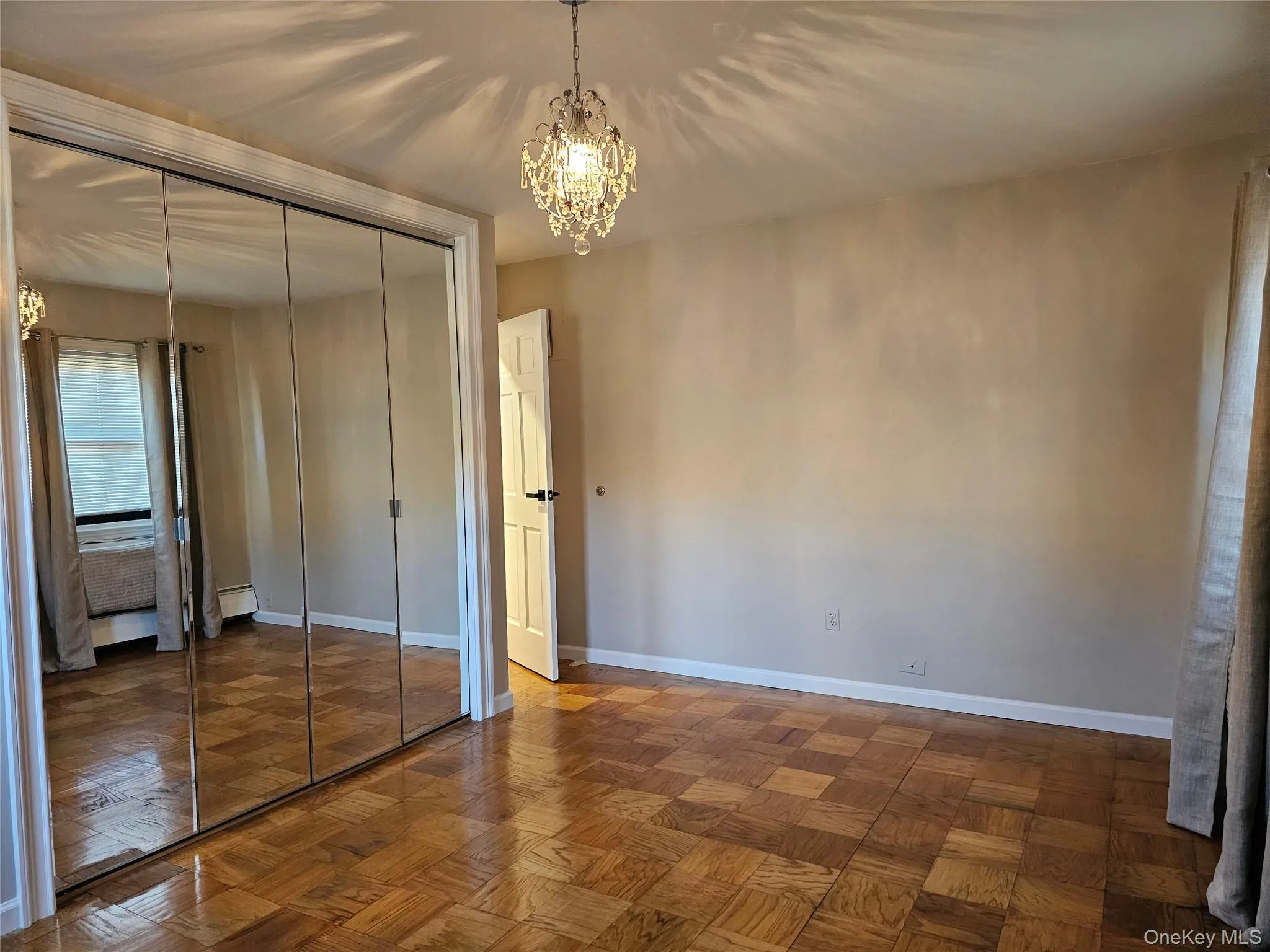 Unfurnished bedroom with a chandelier and a closet Unfurnished bedroom with a chandelier and a closet