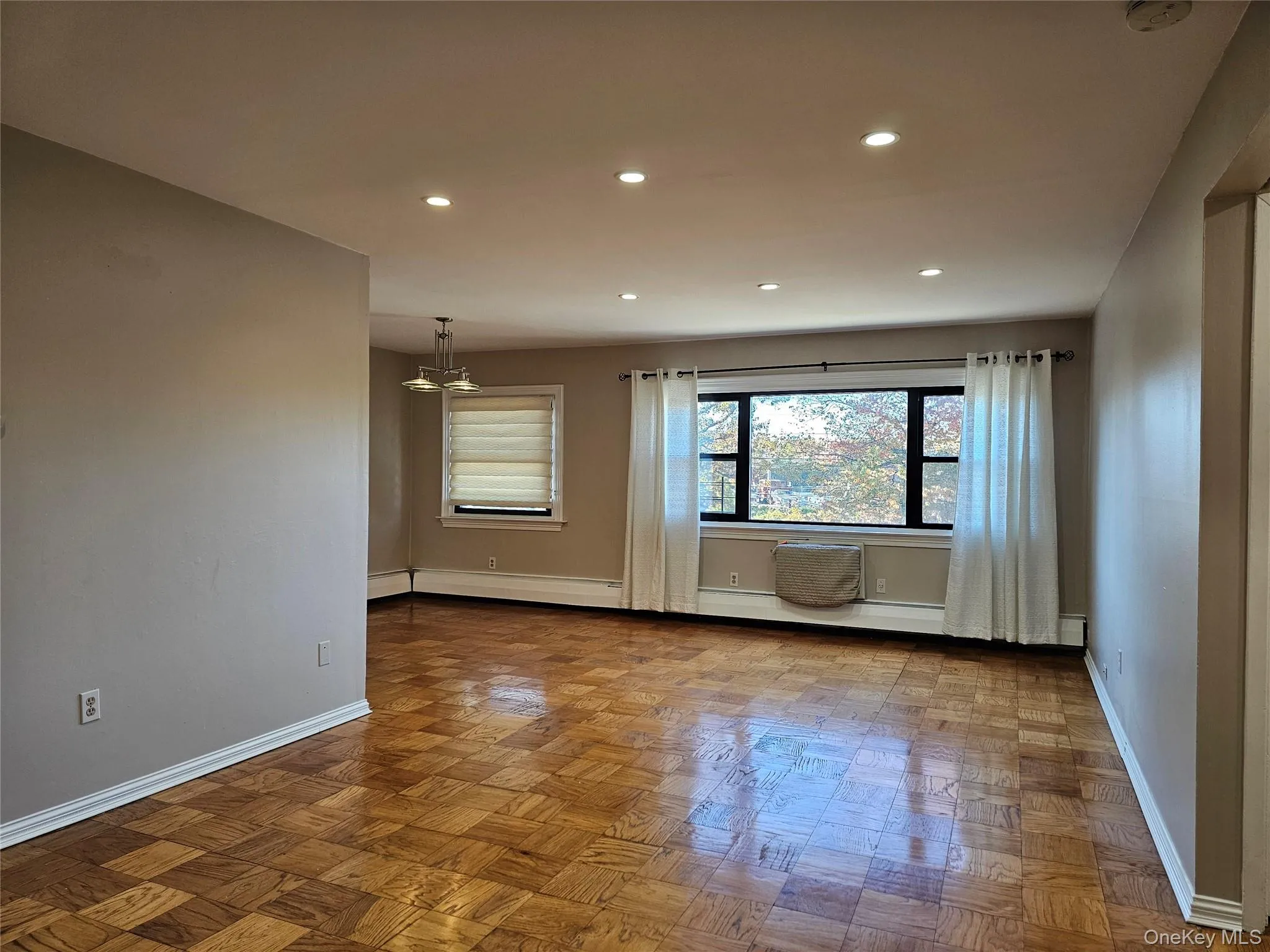 Unfurnished room featuring recessed lighting, a chandelier, and a baseboard heating unit Unfurnished room featuring recessed lighting, a chandelier, and a baseboard heating unit