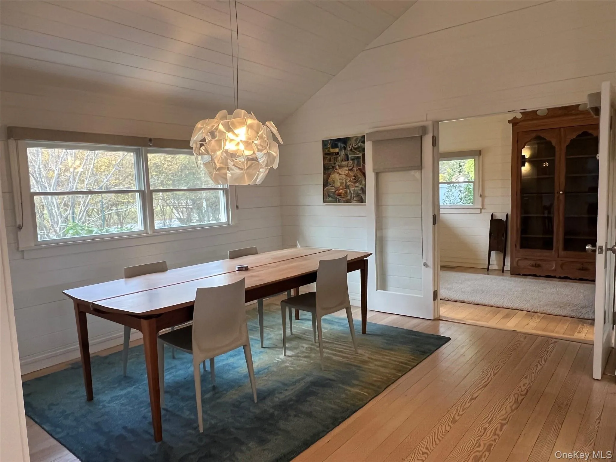 Dining area with vaulted ceiling, white oak flooring, and wooden walls Dining area with vaulted ceiling, white oak flooring, and wooden walls