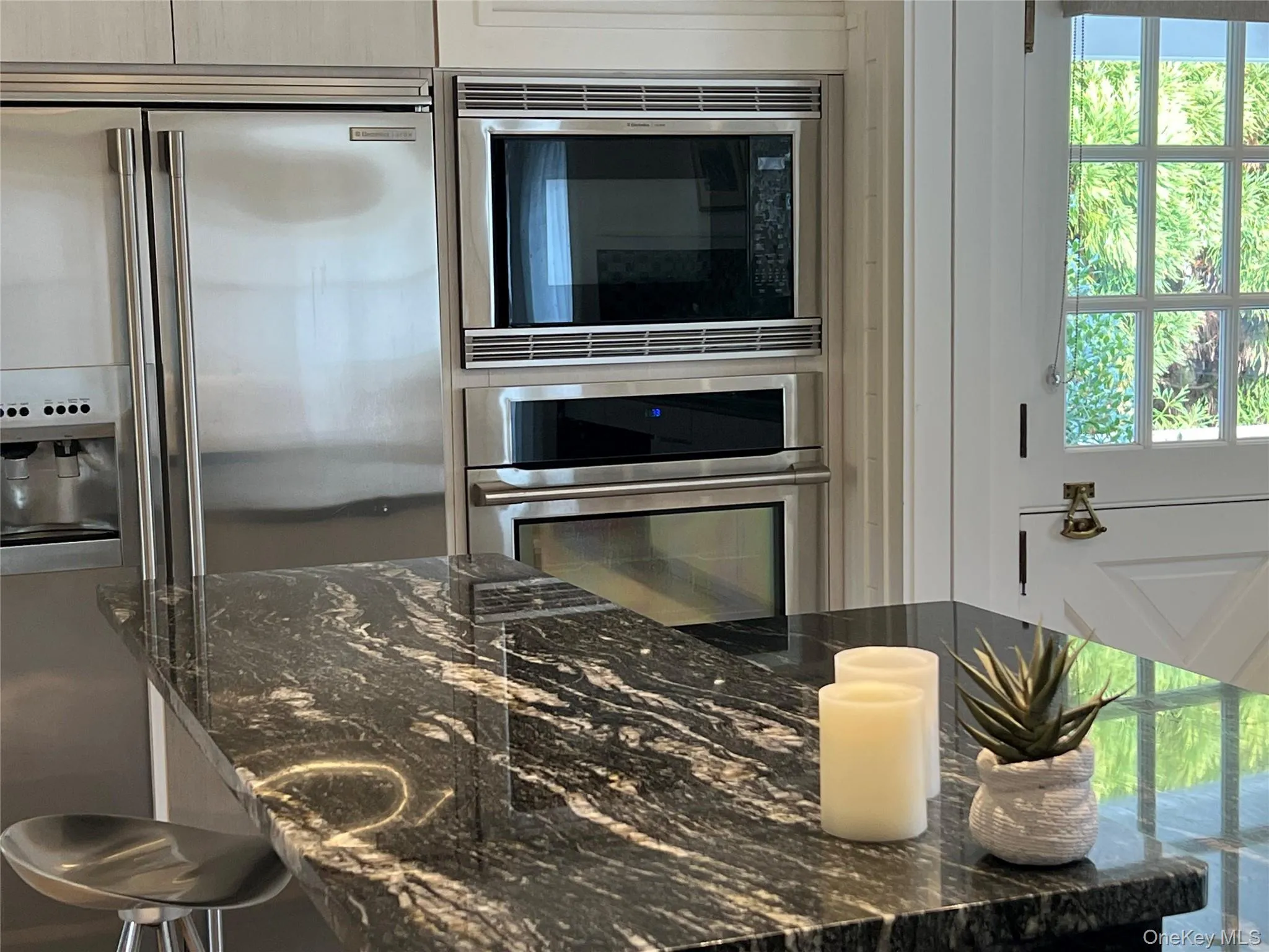 Kitchen with granite countertops, appliances with stainless steel finishes, and a kitchen breakfast bar Kitchen with granite countertops, appliances with stainless steel finishes, and a kitchen breakfast bar