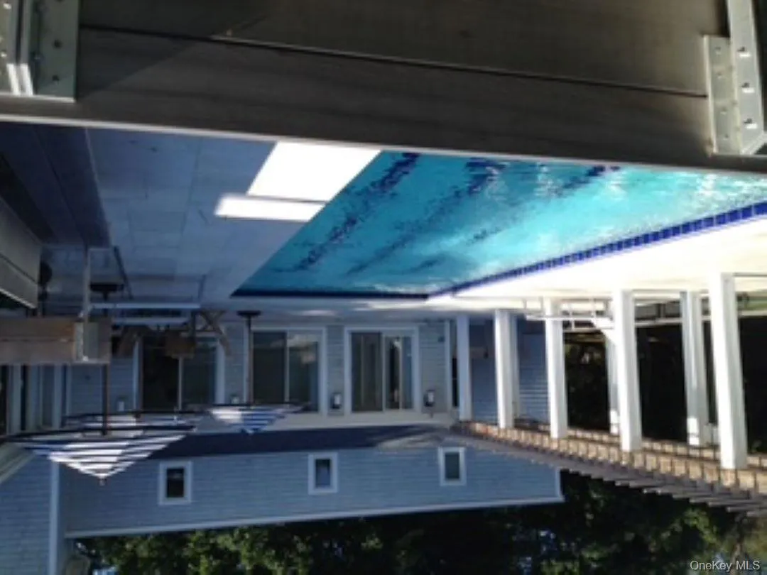 Rear view of property featuring a pergola, a patio area, and an outdoor pool Rear view of property featuring a pergola, a patio area, and an outdoor pool