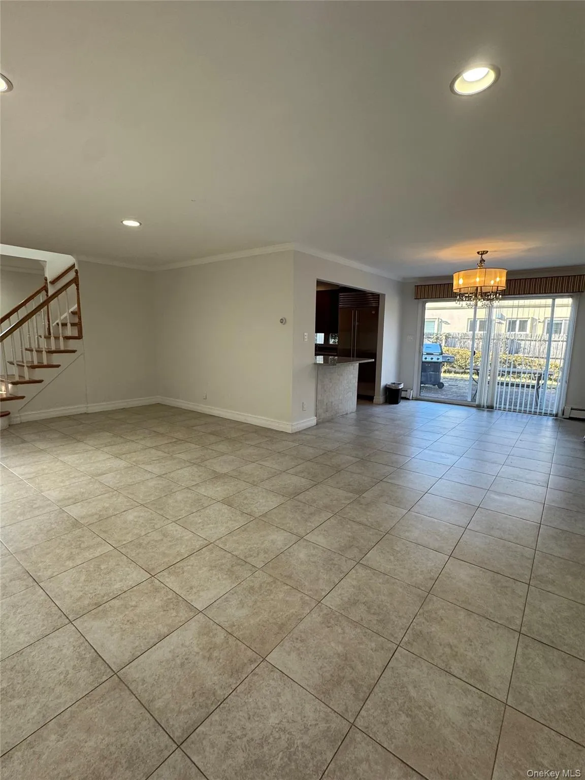 Unfurnished living room with recessed lighting, stairs, a chandelier, light tile patterned flooring, and crown molding Unfurnished living room with recessed lighting, stairs, a chandelier, light tile patterned flooring, and crown molding