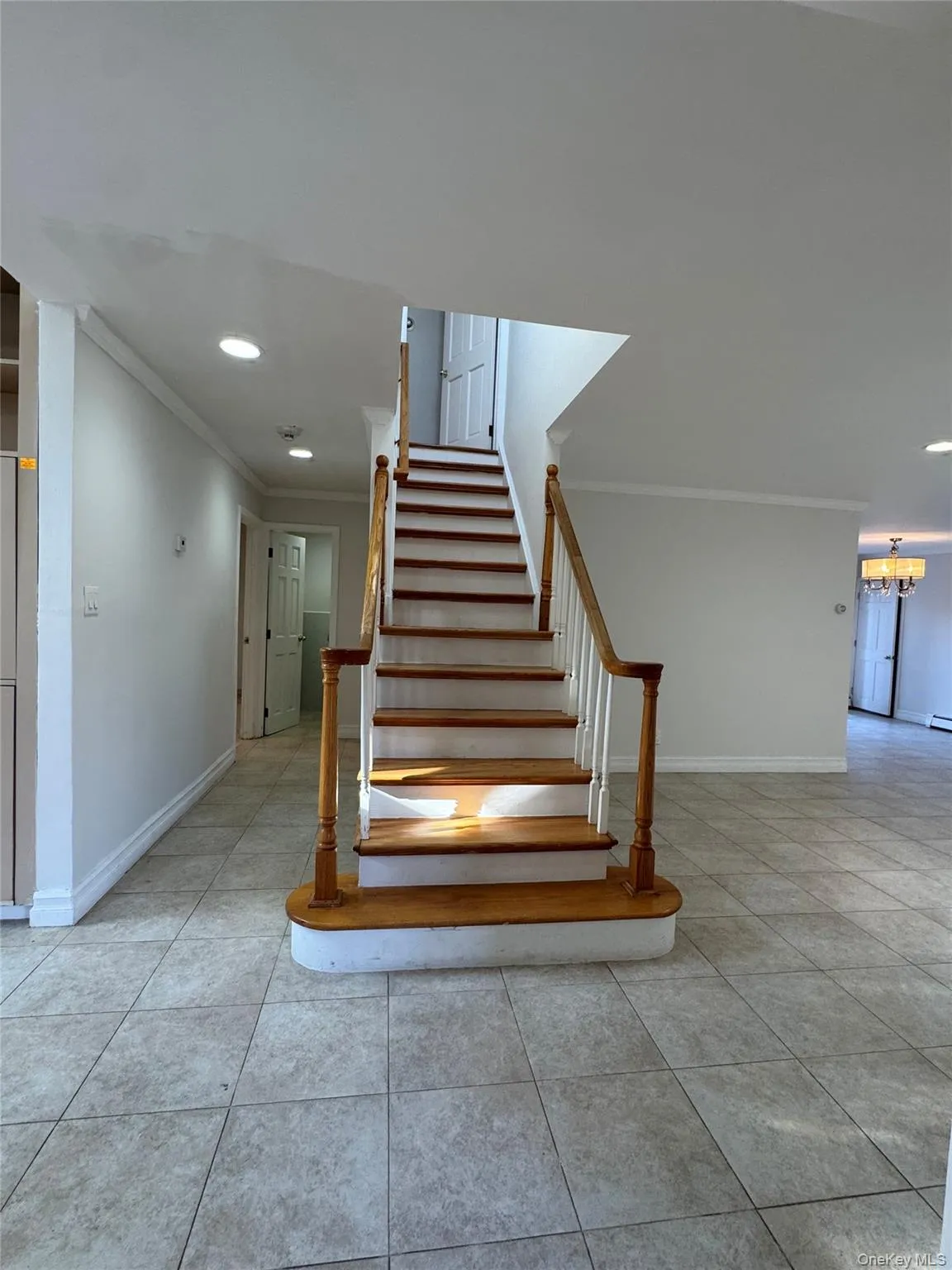 Stairway featuring recessed lighting, tile patterned floors, ornamental molding, and a chandelier Stairway featuring recessed lighting, tile patterned floors, ornamental molding, and a chandelier