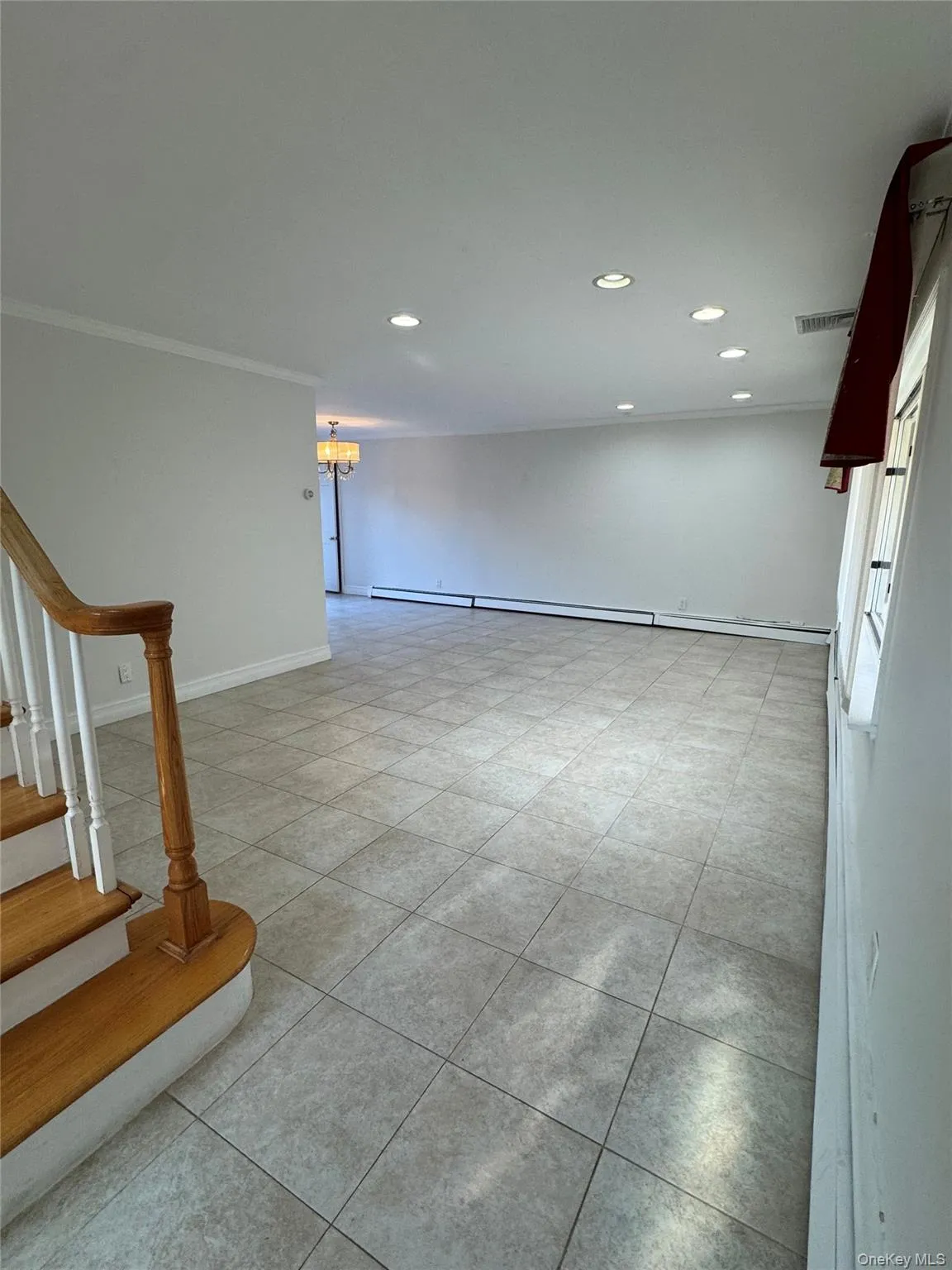 Spare room featuring recessed lighting, stairway, light tile patterned flooring, a baseboard heating unit, and a chandelier Spare room featuring recessed lighting, stairway, light tile patterned flooring, a baseboard heating unit, and a chandelier