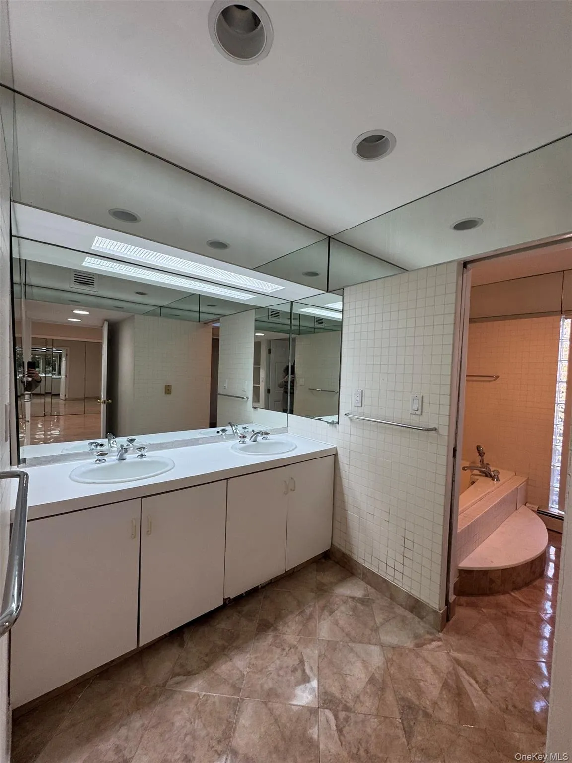 Full bath with double vanity, a bath, and tile walls Full bath with double vanity, a bath, and tile walls