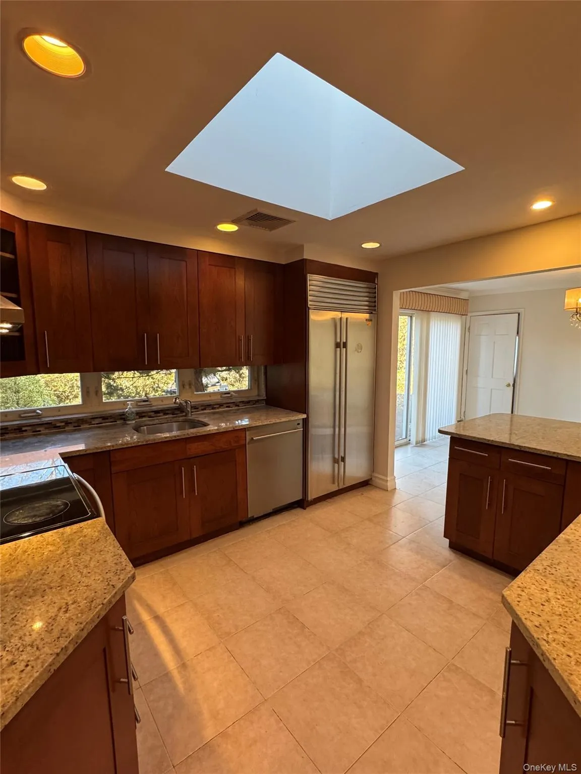 Kitchen featuring light stone countertops, appliances with stainless steel finishes, recessed lighting, and glass insert cabinets Kitchen featuring light stone countertops, appliances with stainless steel finishes, recessed lighting, and glass insert cabinets